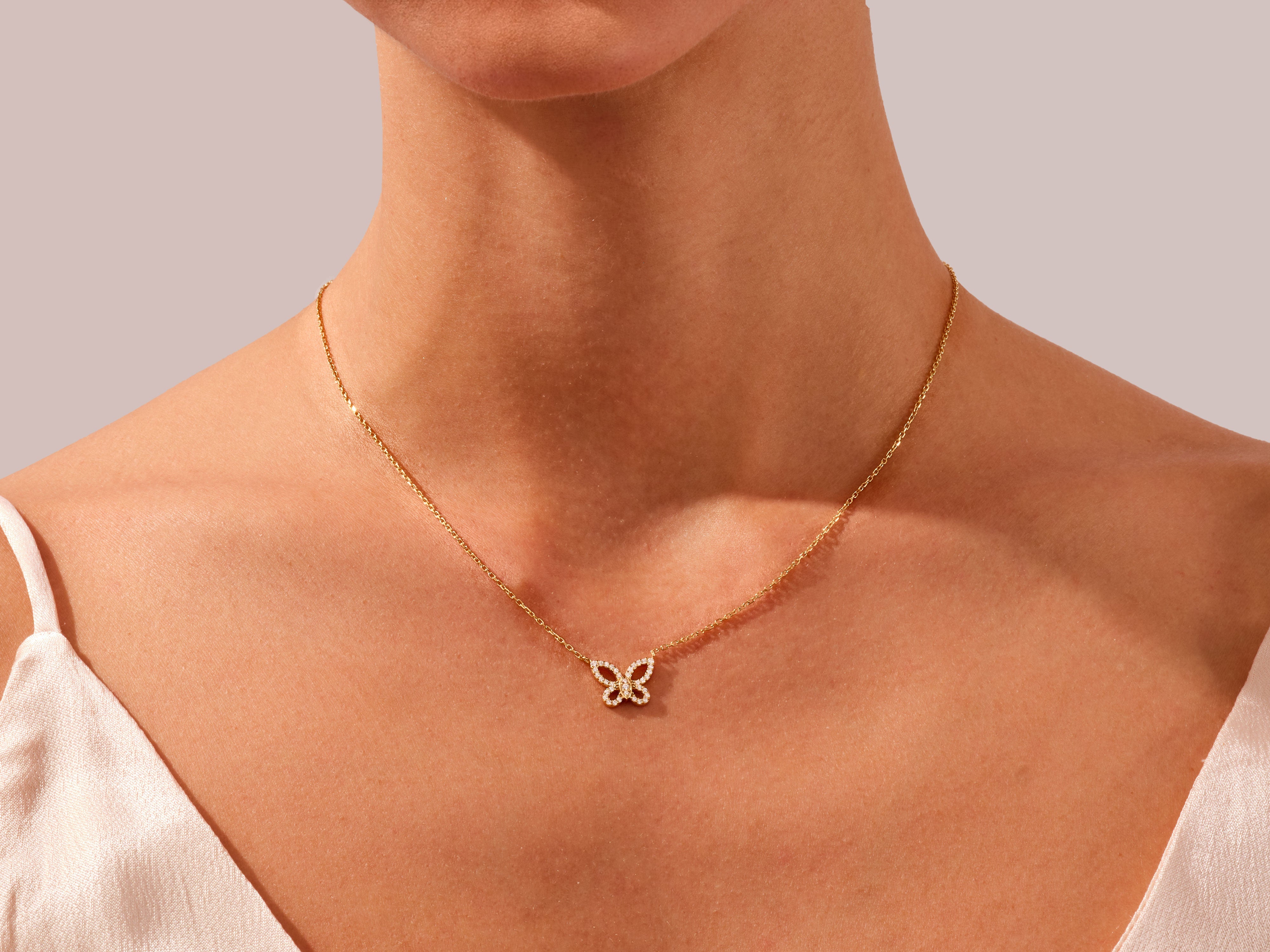 Gold butterfly necklace with diamonds on a woman's neck