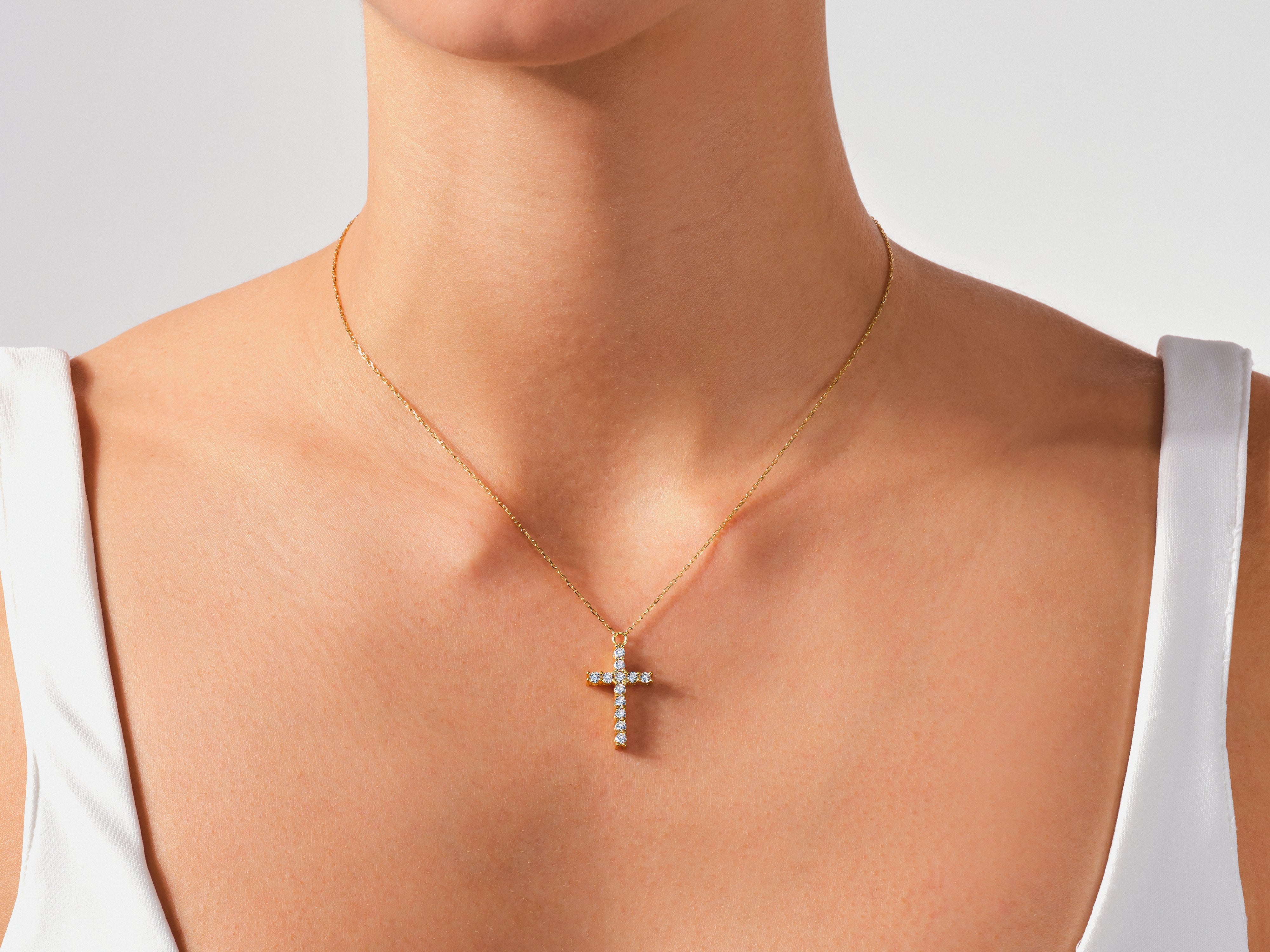Diamond cross necklace on a woman's neck, fine jewelry