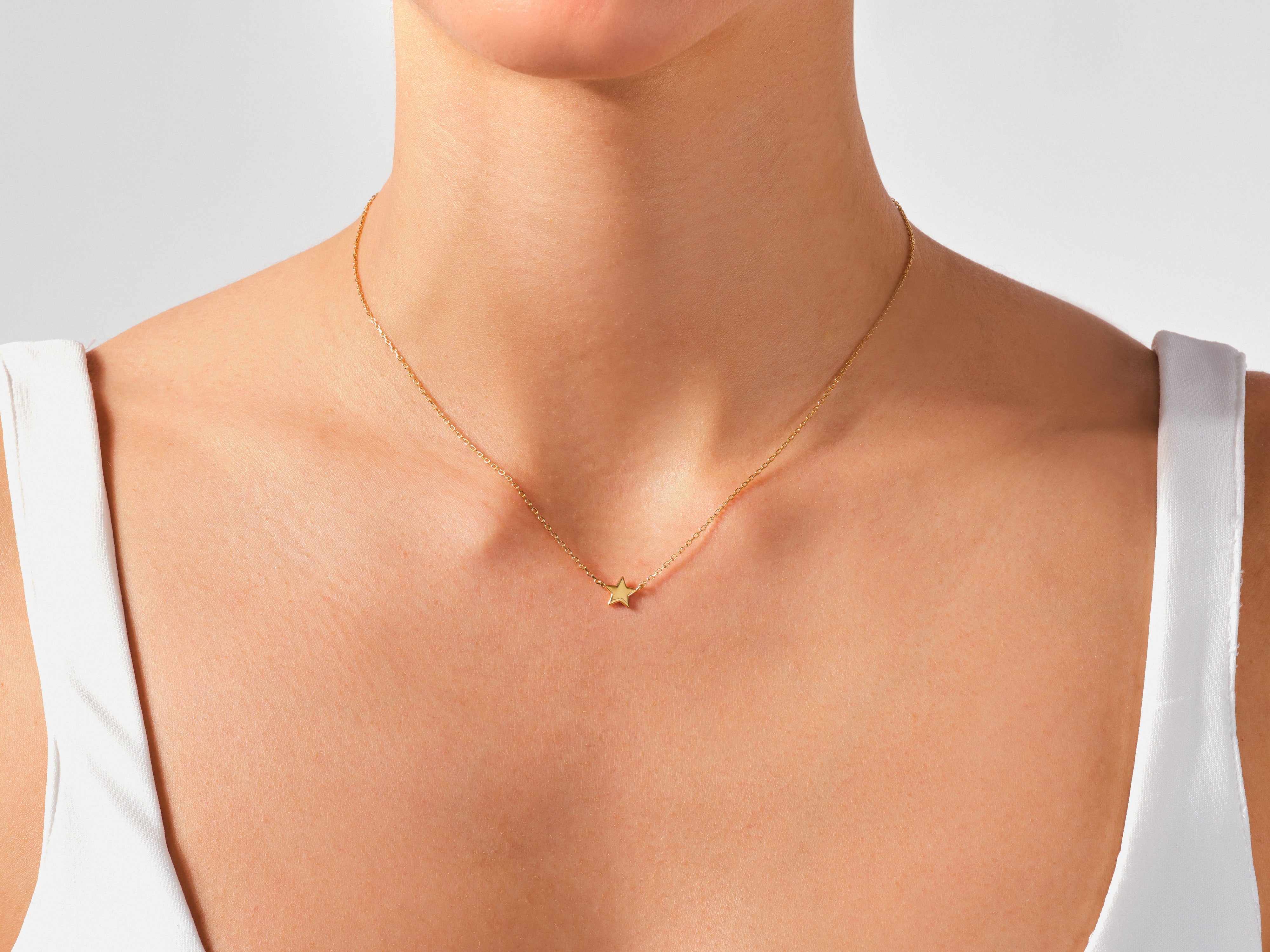Gold star necklace on a woman's neck, fine jewelry