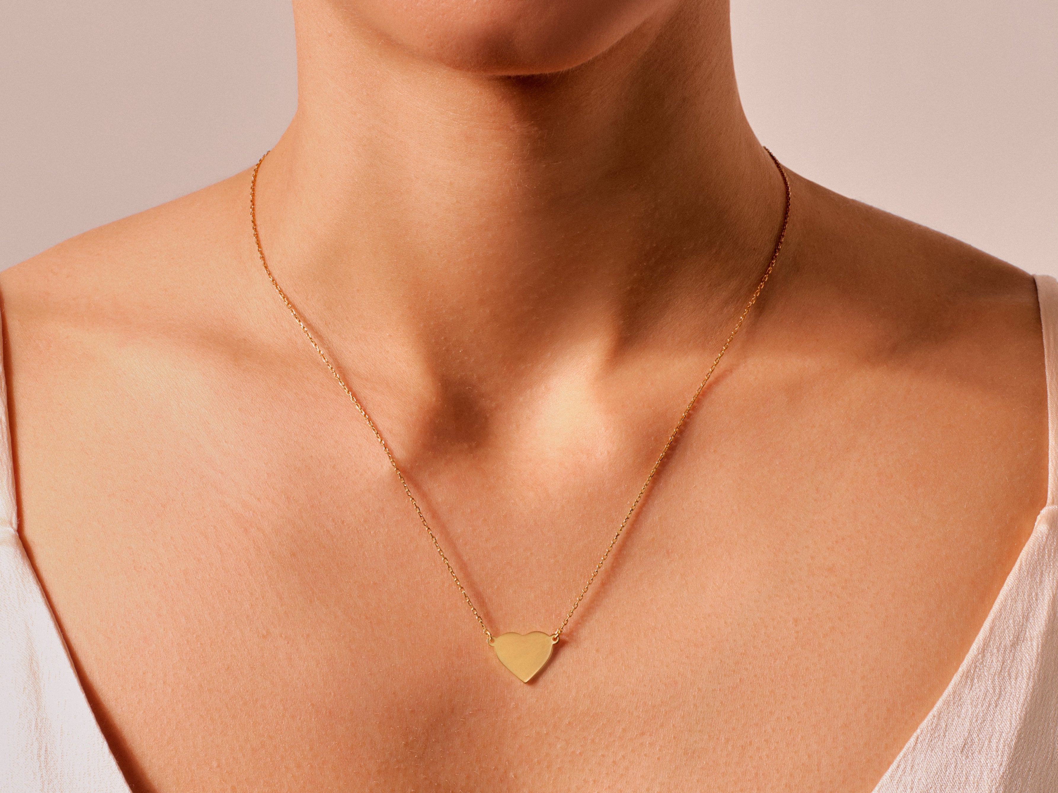 Gold heart necklace on a woman's neck, jewelry