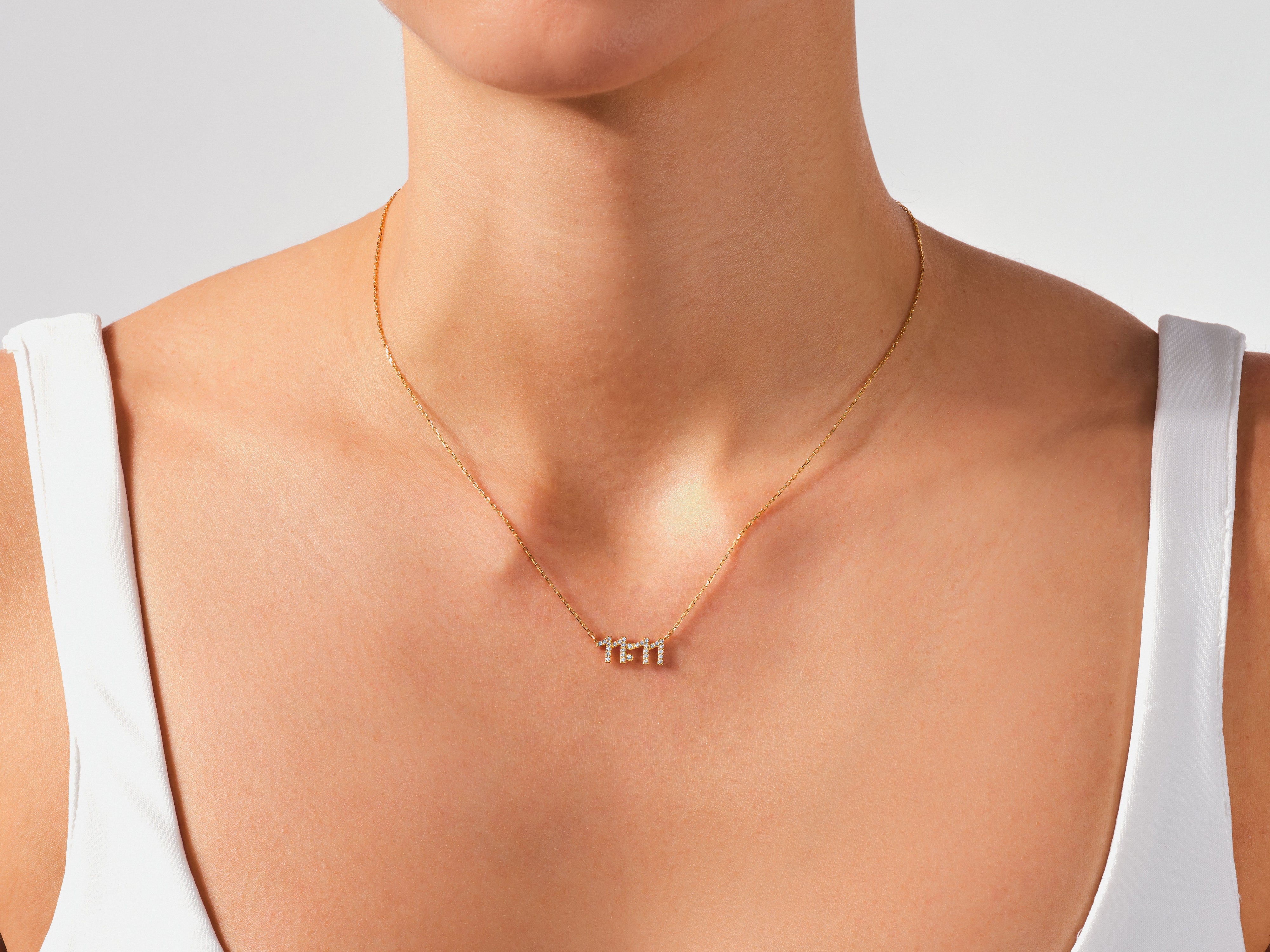 Gold necklace with diamond numbers "11" on a woman's neck
