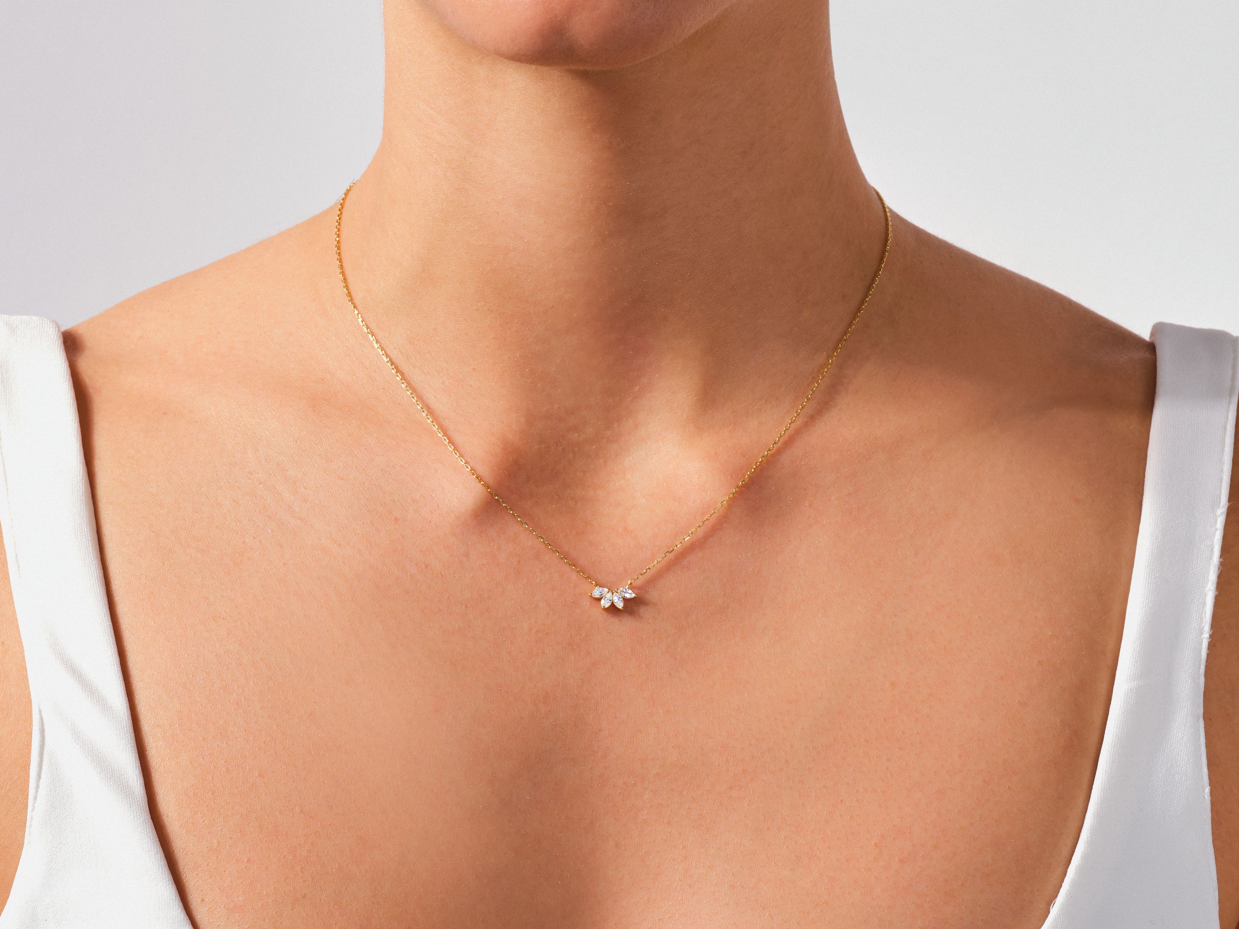 Gold necklace with diamond cluster pendant on a woman's neck