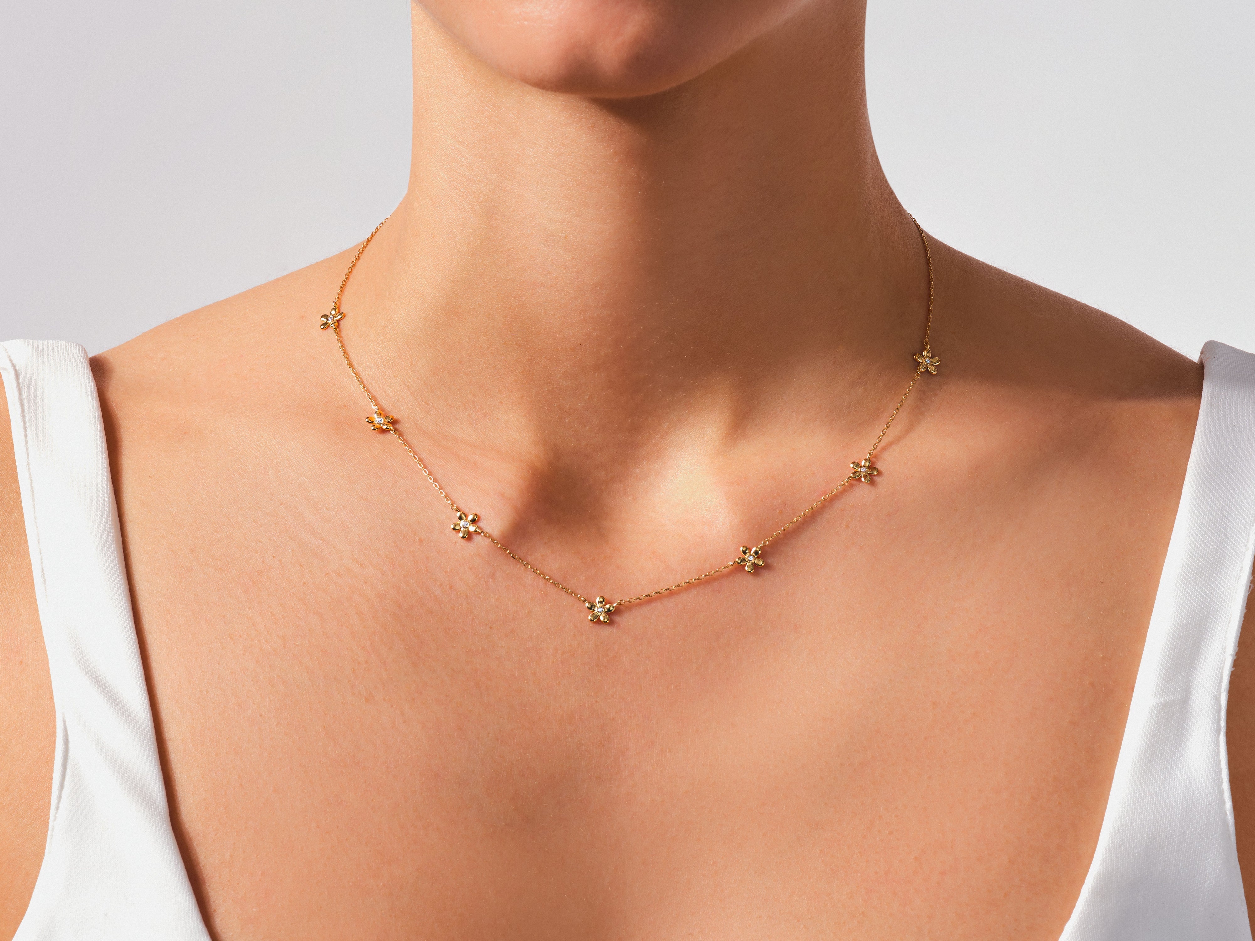 Gold flower necklace with diamonds on a woman's neck