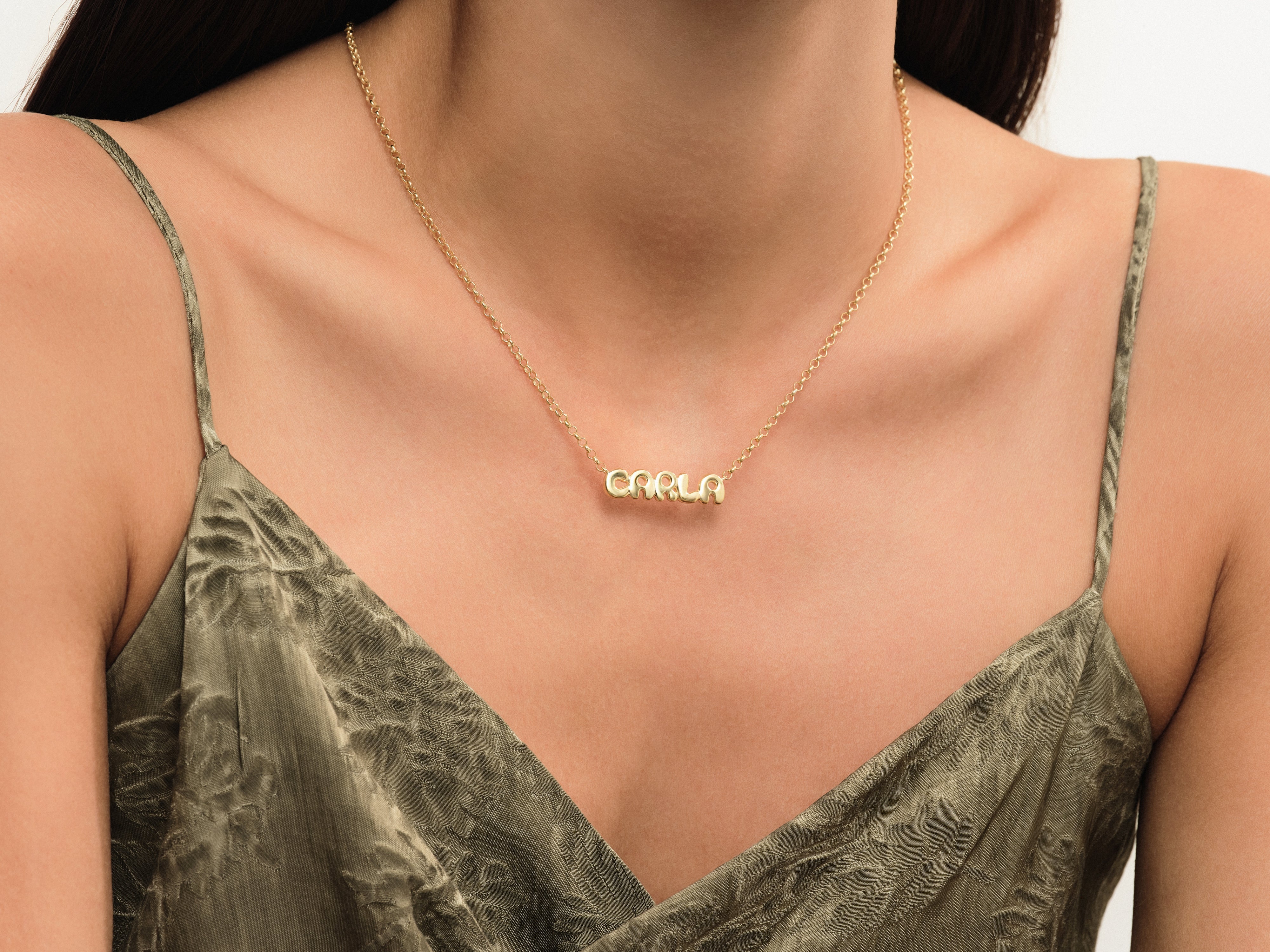 Gold name necklace "CARLA" on a woman's neck