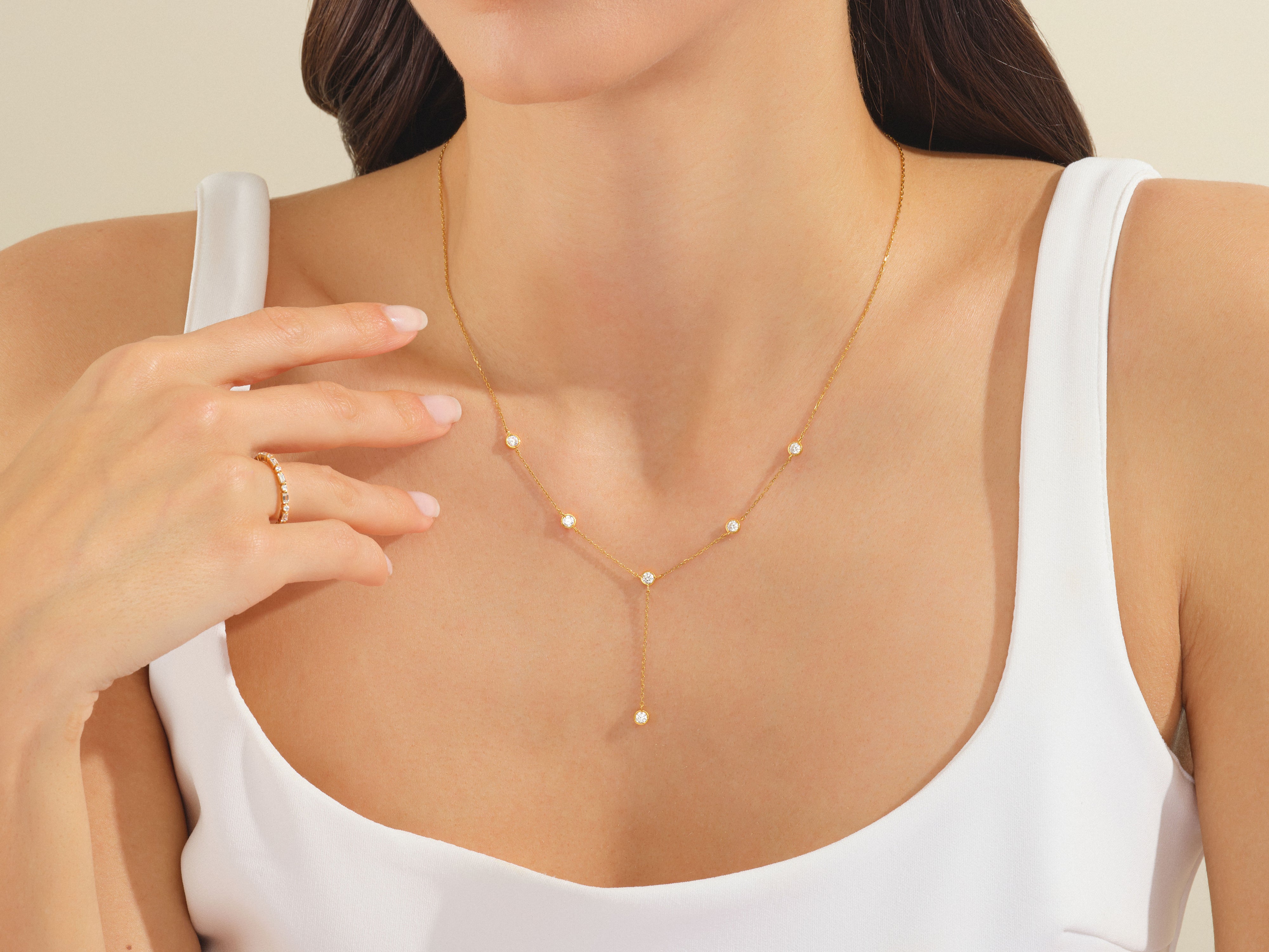 Gold diamond necklace and ring on a woman's neck and hand