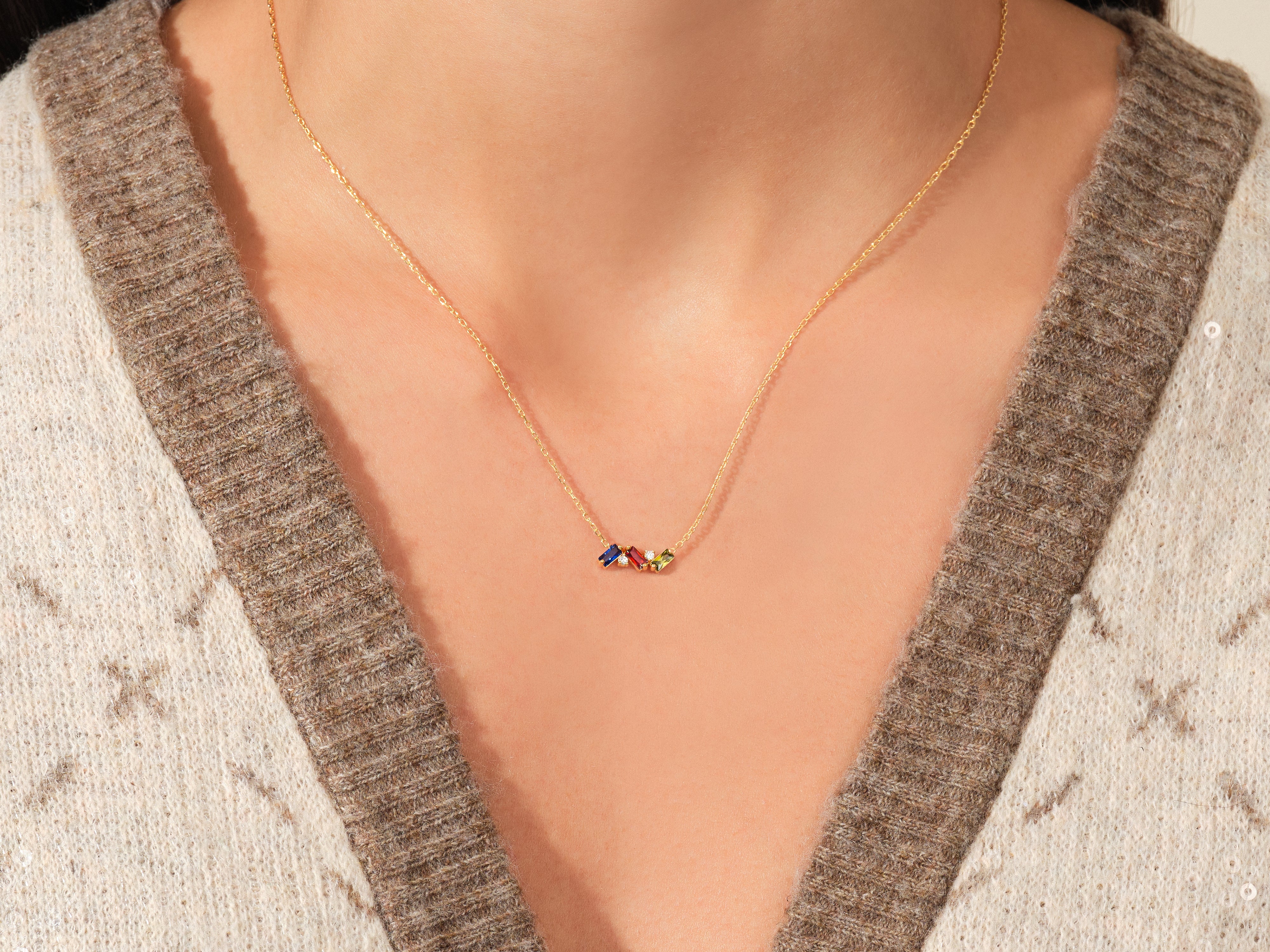 Gold necklace with colorful gemstone charms on a woman's neck