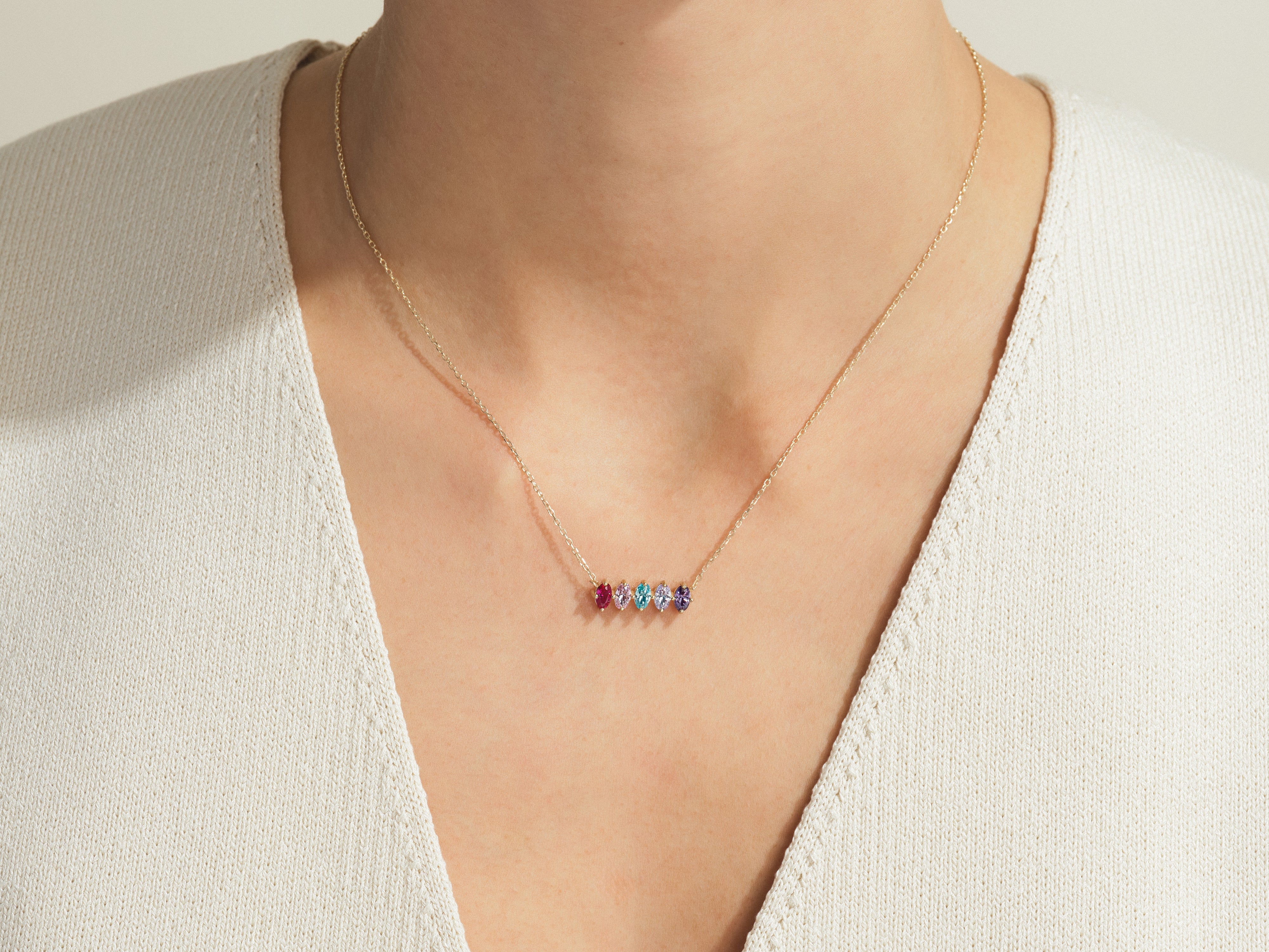 Gold necklace with colorful gemstones on a woman's neck