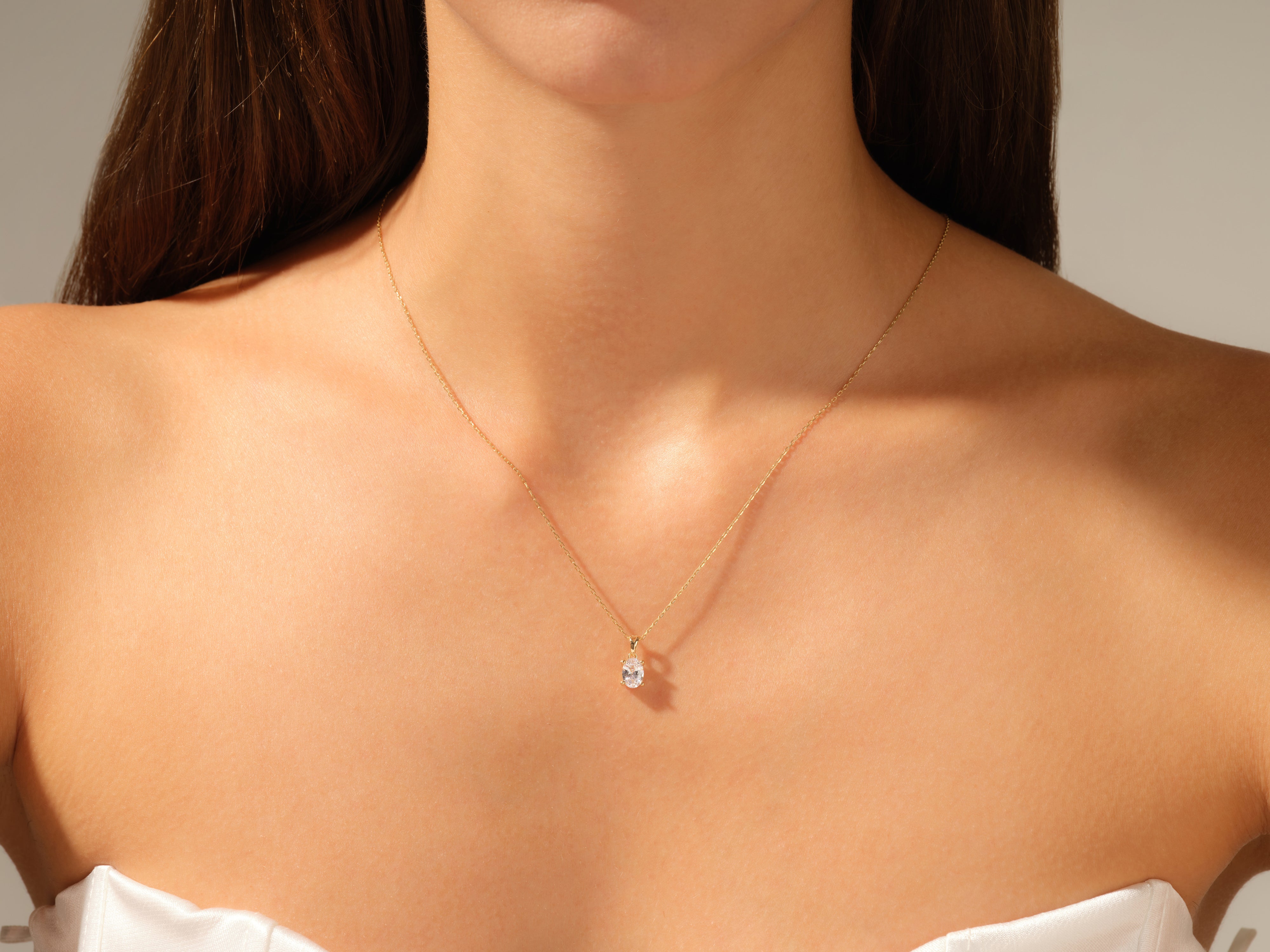 Gold necklace with diamond pendant on woman's neck