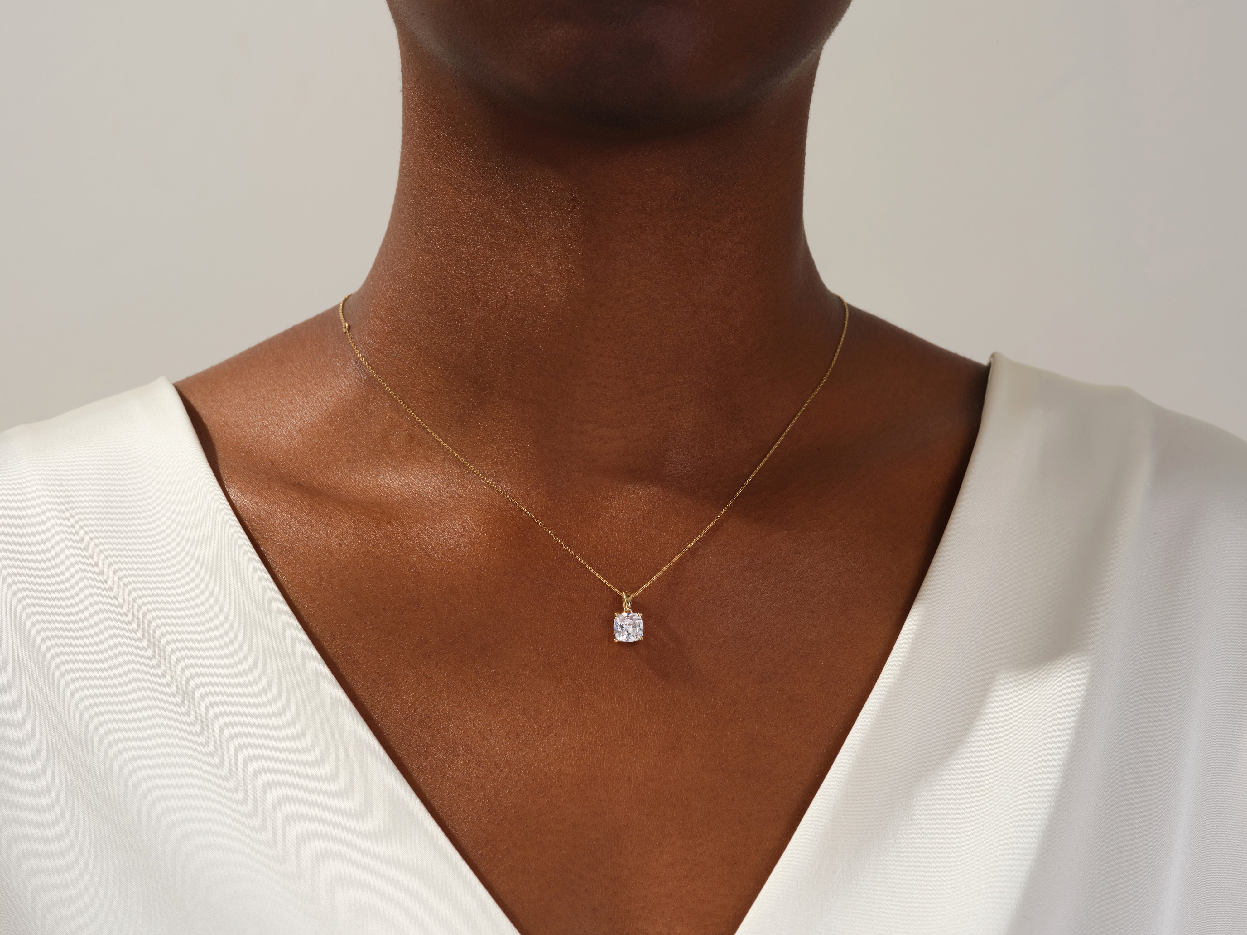 Gold necklace with diamond pendant on a woman's neck