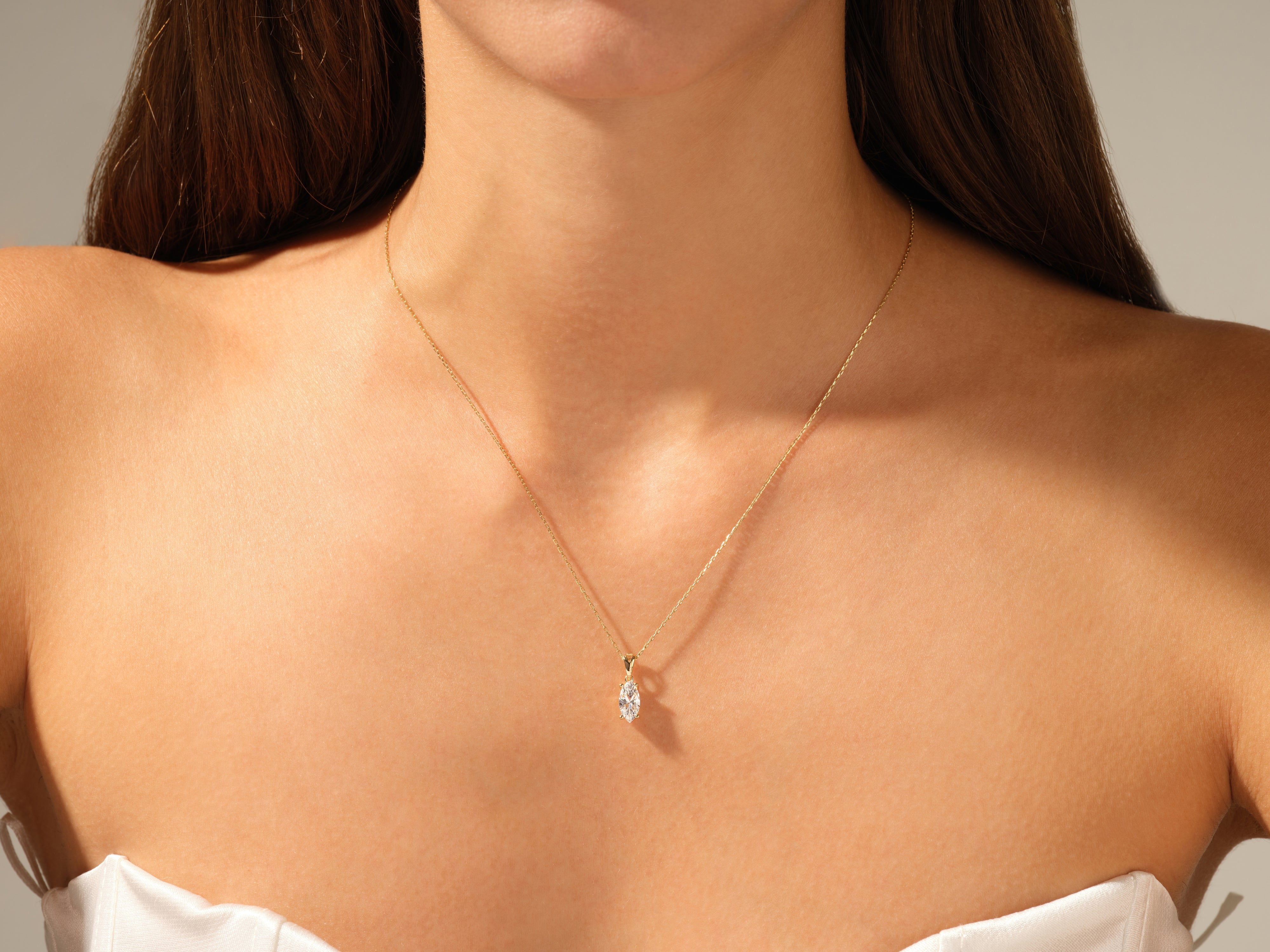 Gold necklace with diamond pendant on a woman's neck
