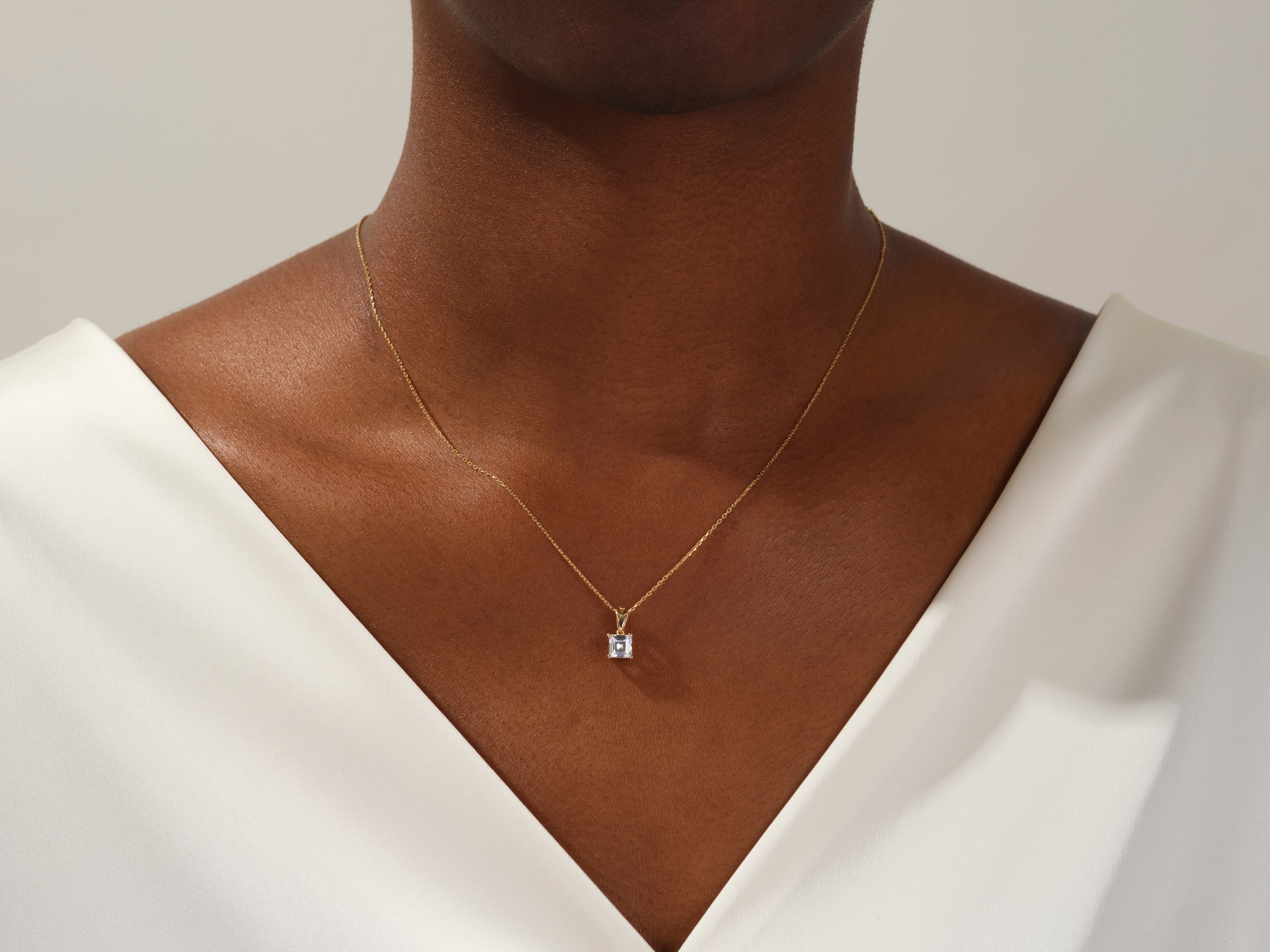 Gold necklace with diamond pendant on model