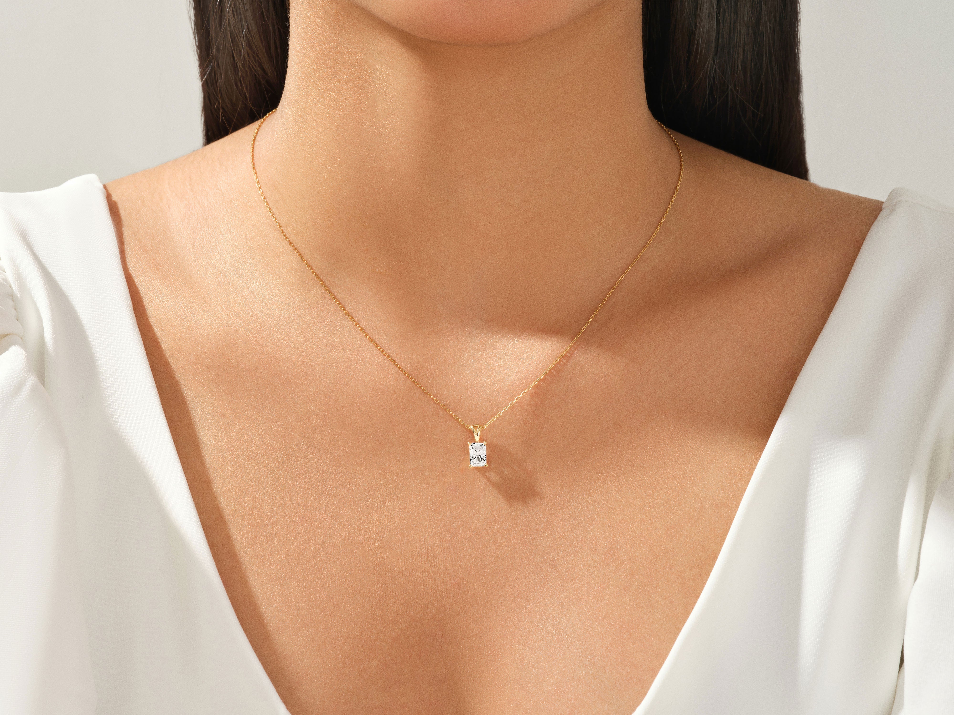 Gold necklace with a radiant diamond pendant on a woman's neck