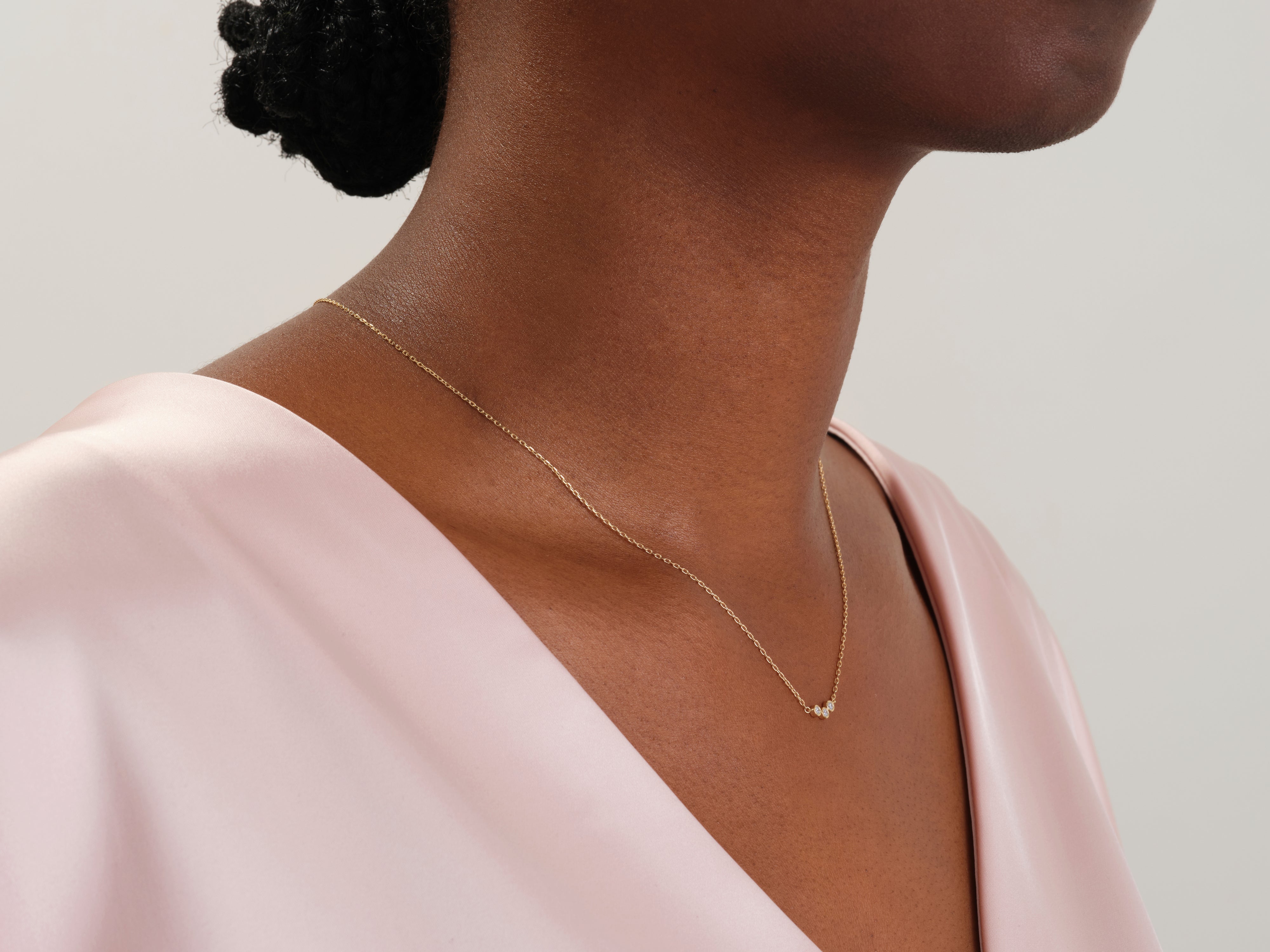 Gold necklace with three diamonds on a woman's neck