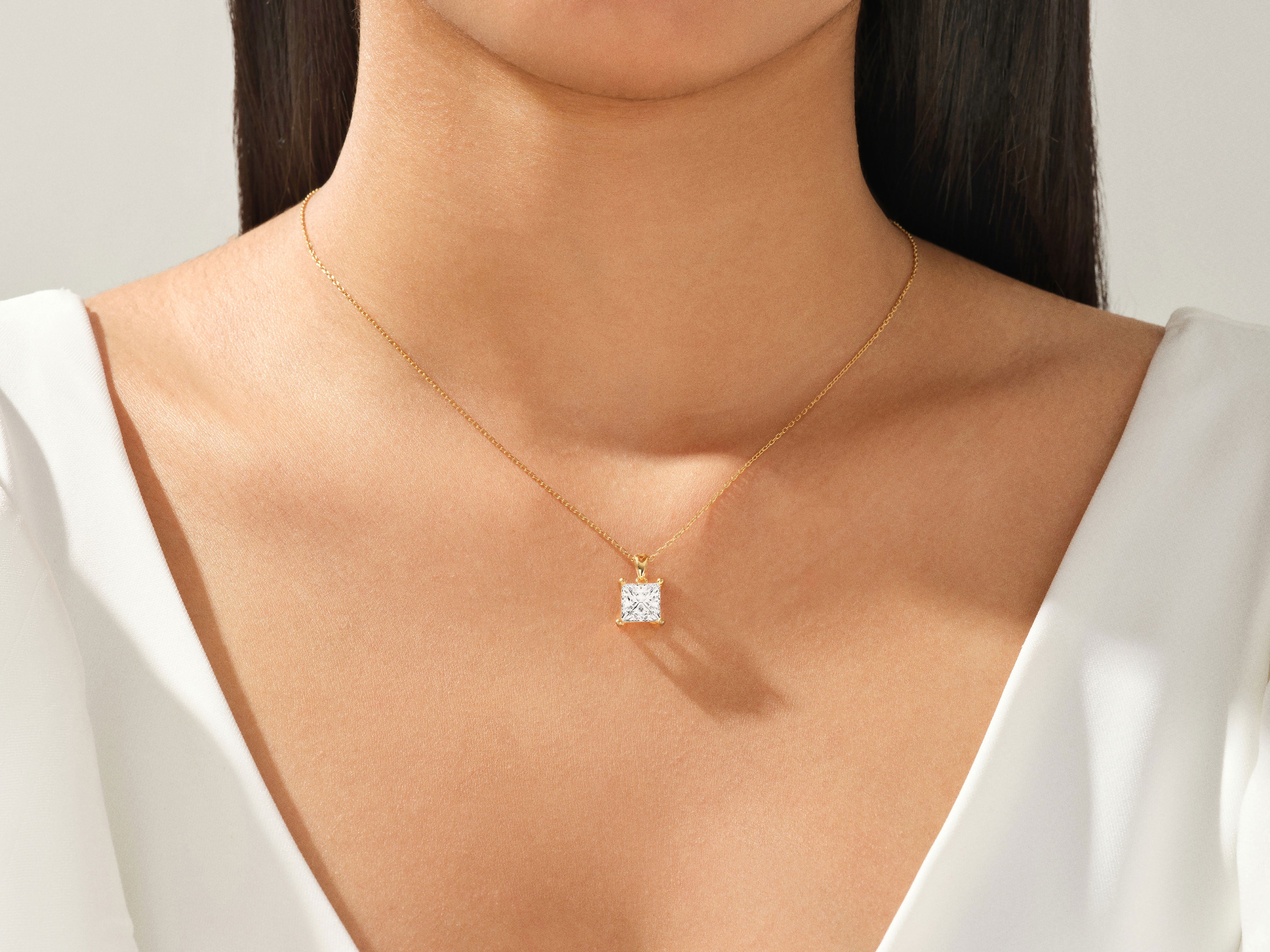 Gold necklace with princess cut diamond pendant on model