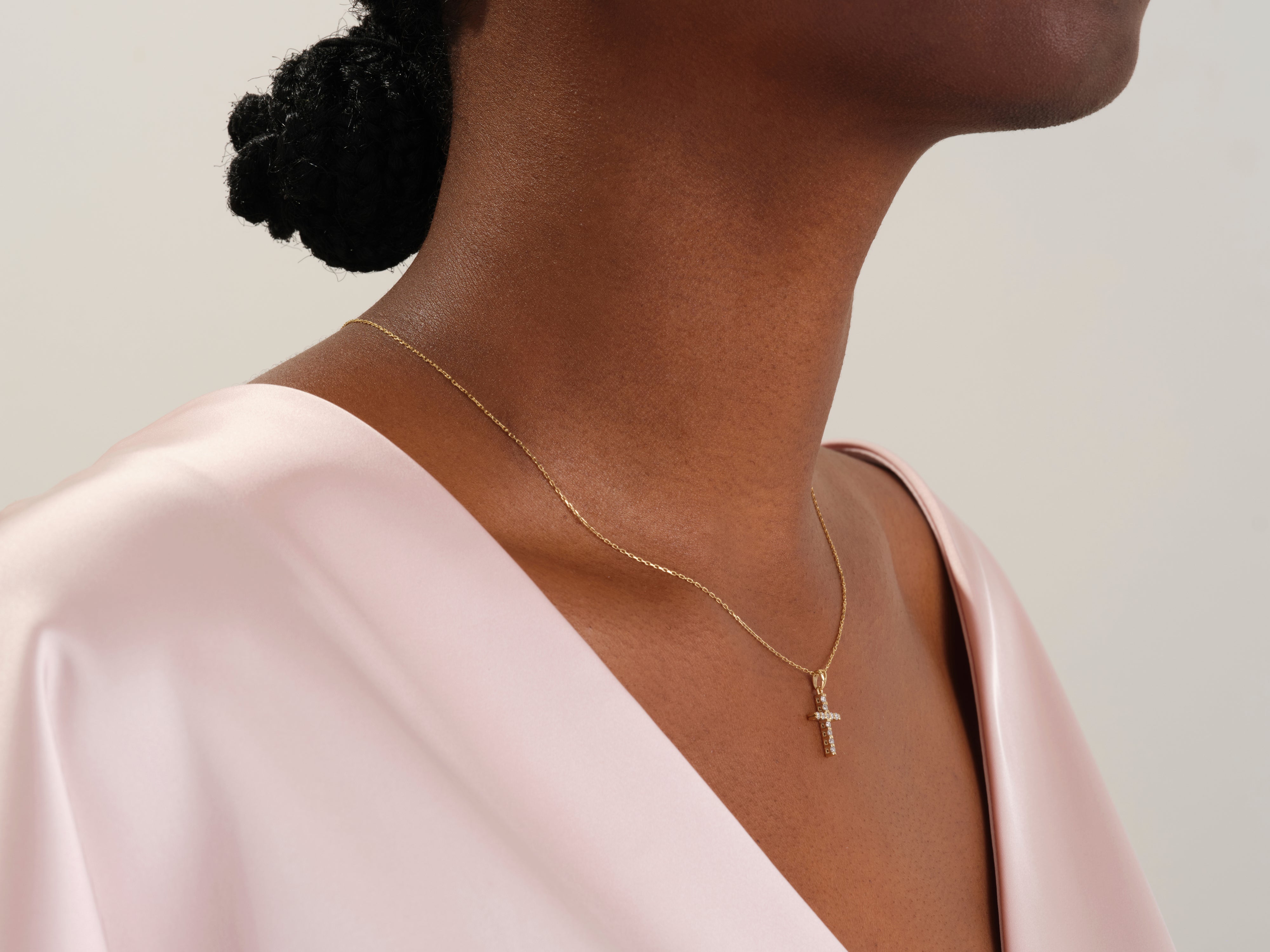 Gold diamond cross necklace on a woman's neck