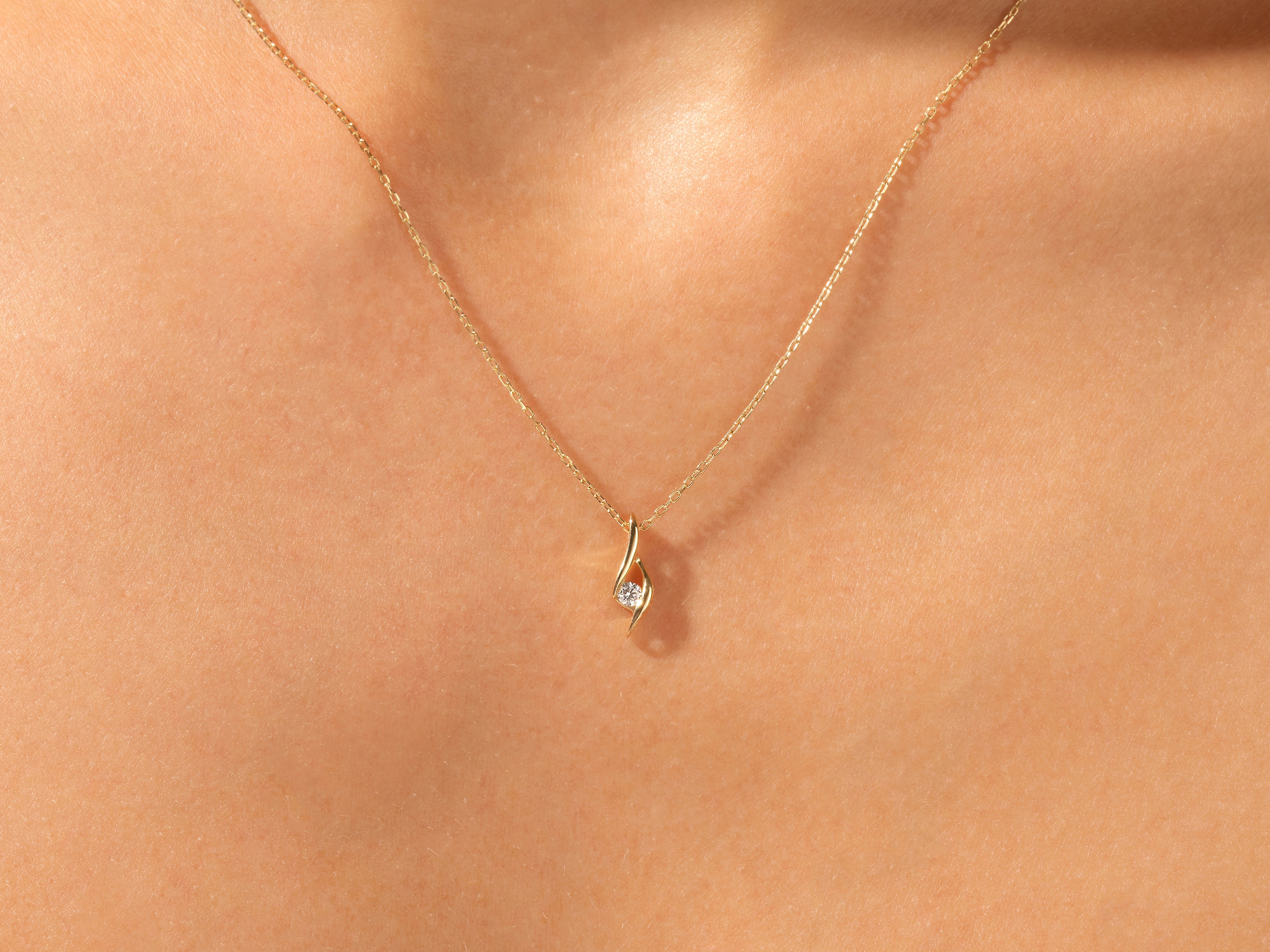 Gold diamond pendant necklace on skin