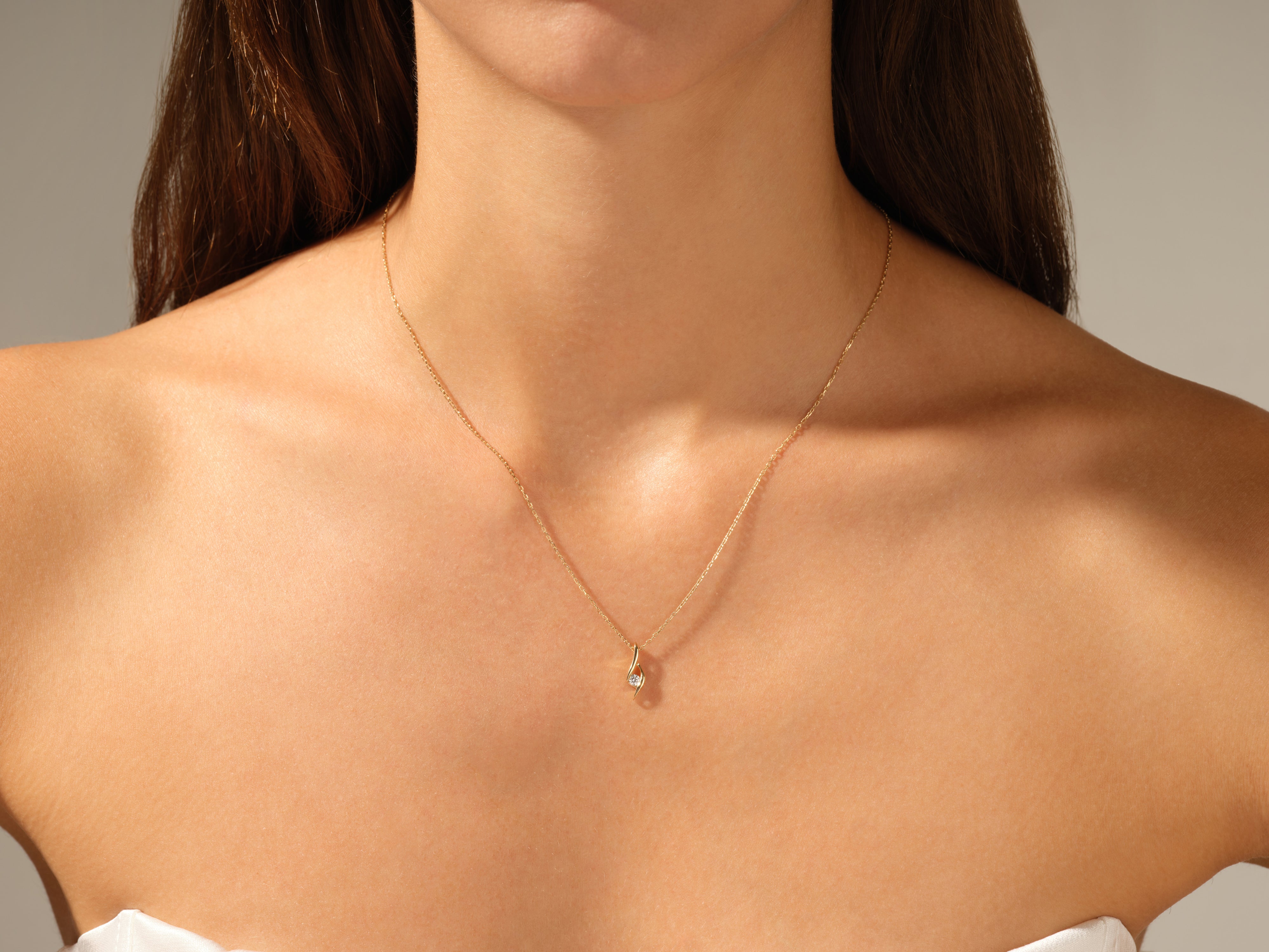 Gold necklace with diamond pendant on a woman's neck