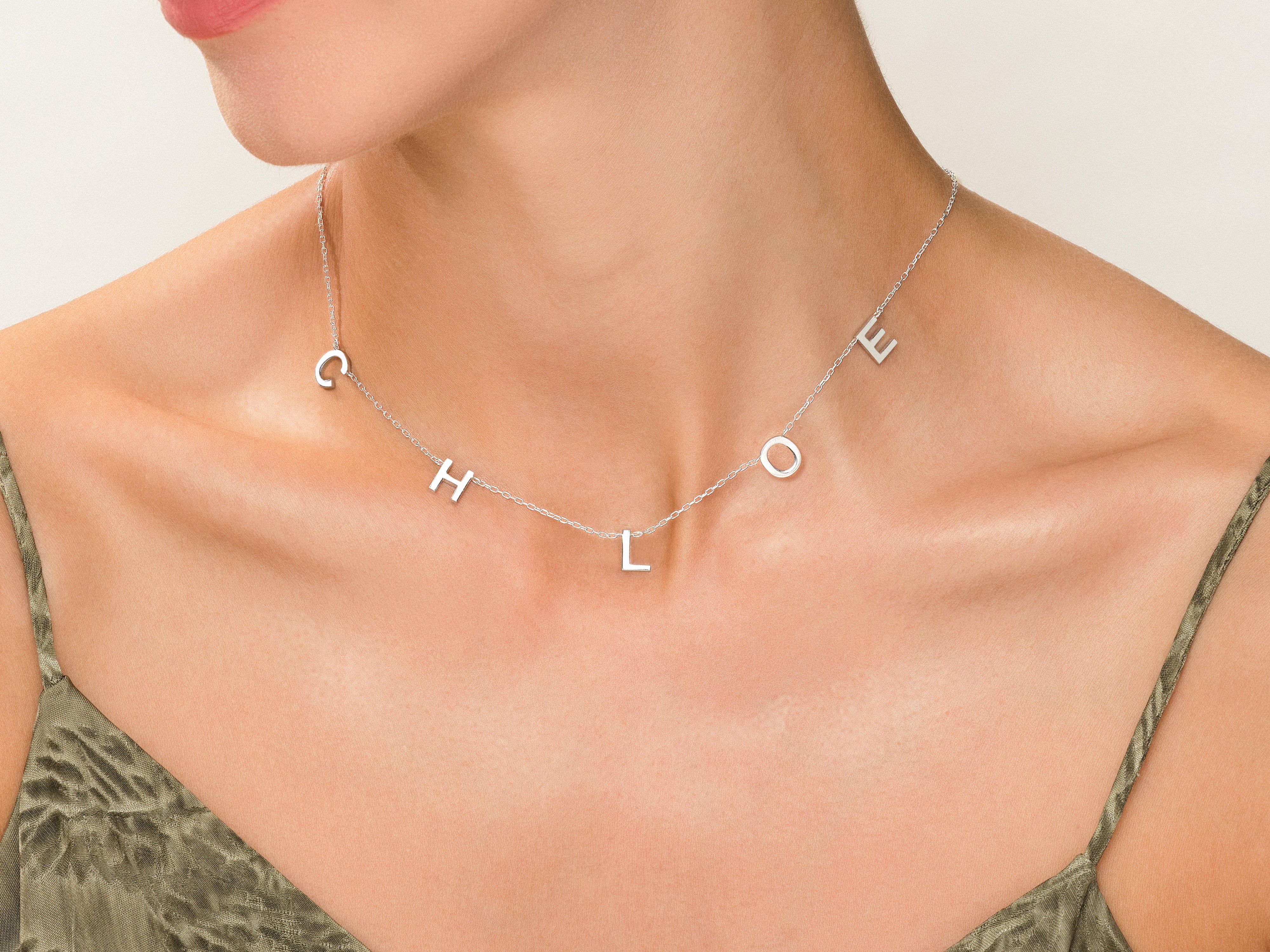 Silver "Chloe" initial necklace on a woman's neck