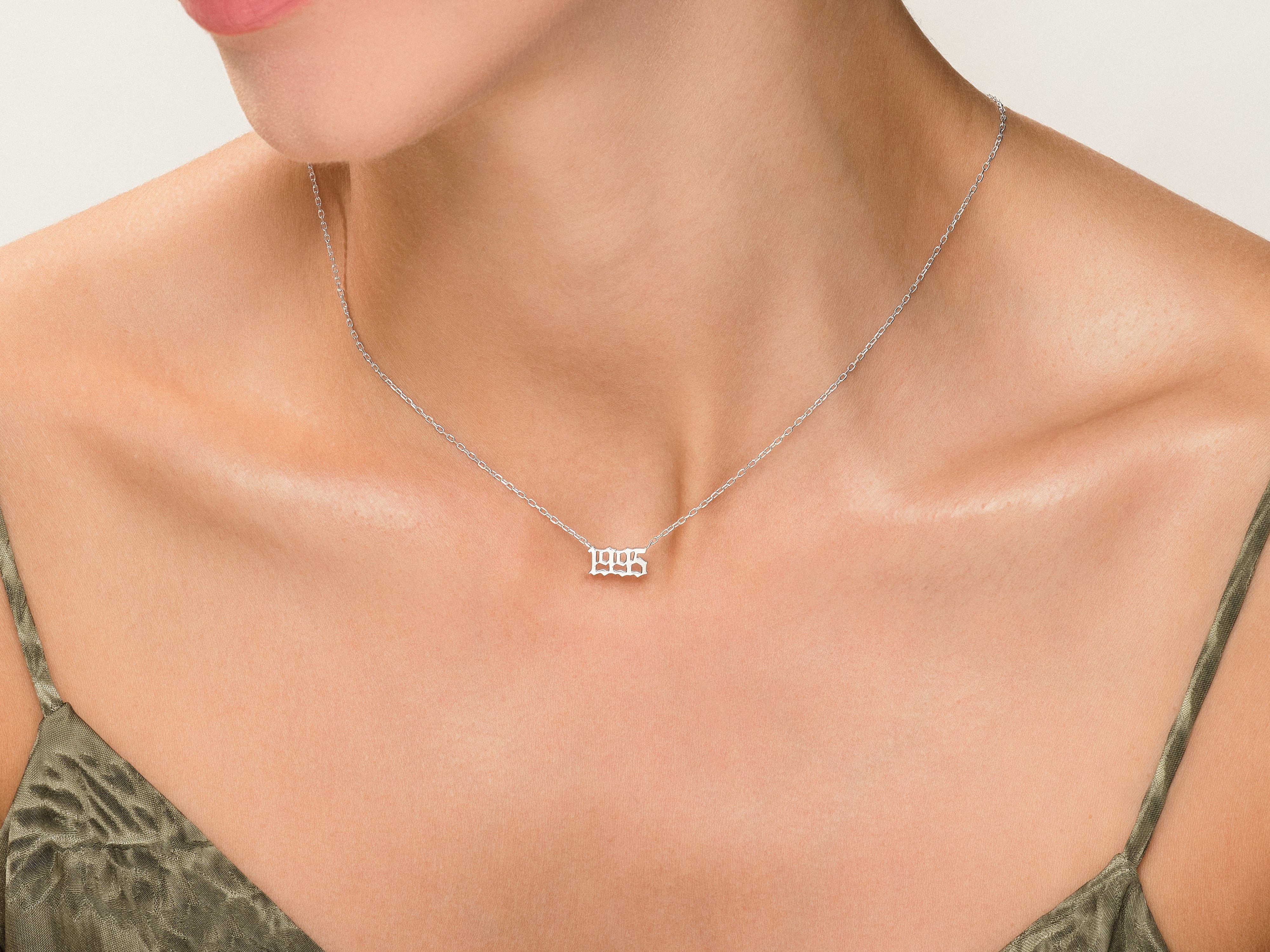 Silver '1995' year necklace on a woman's neck