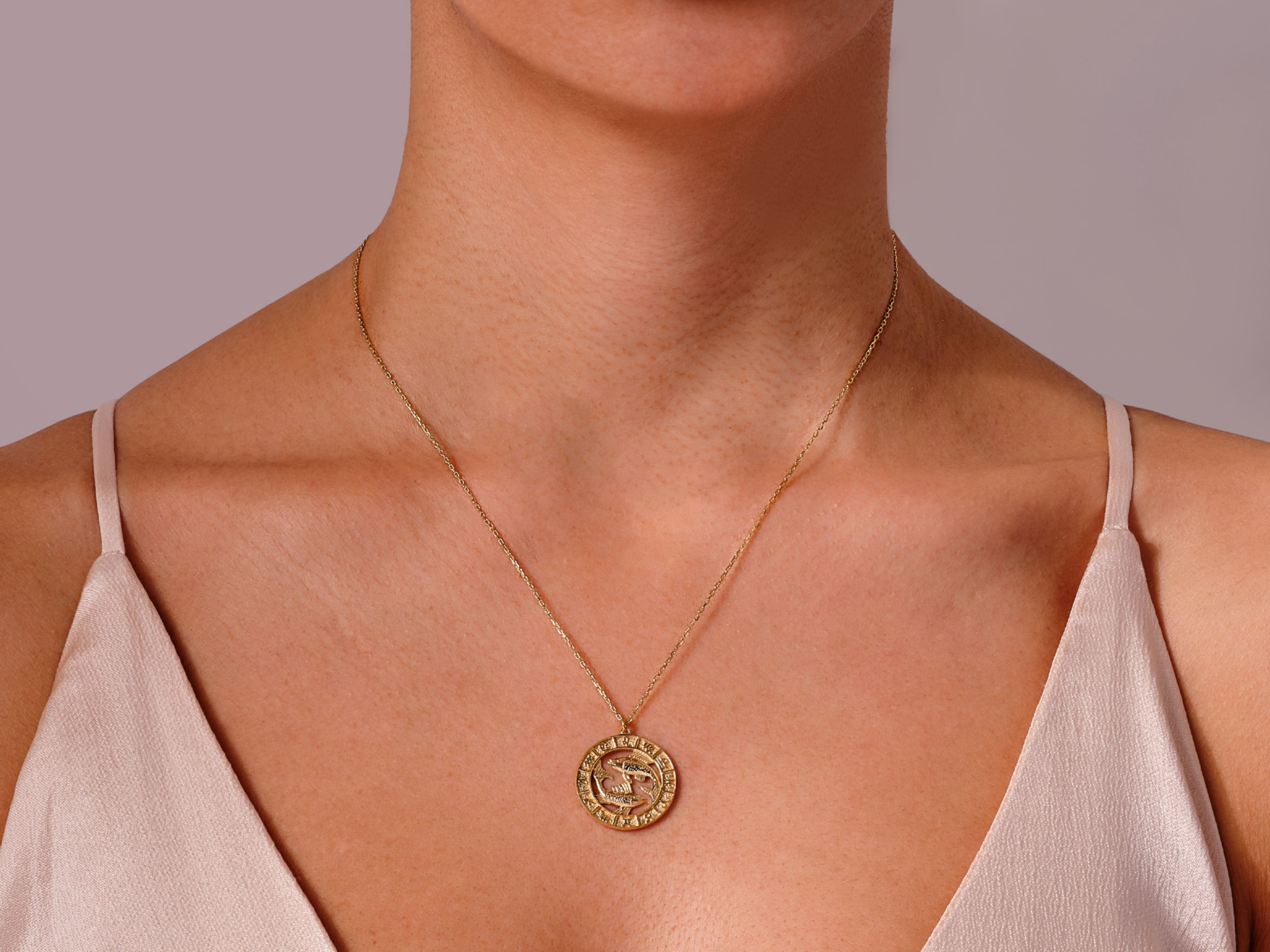 Gold zodiac necklace on a woman's neck, jewelry for sale