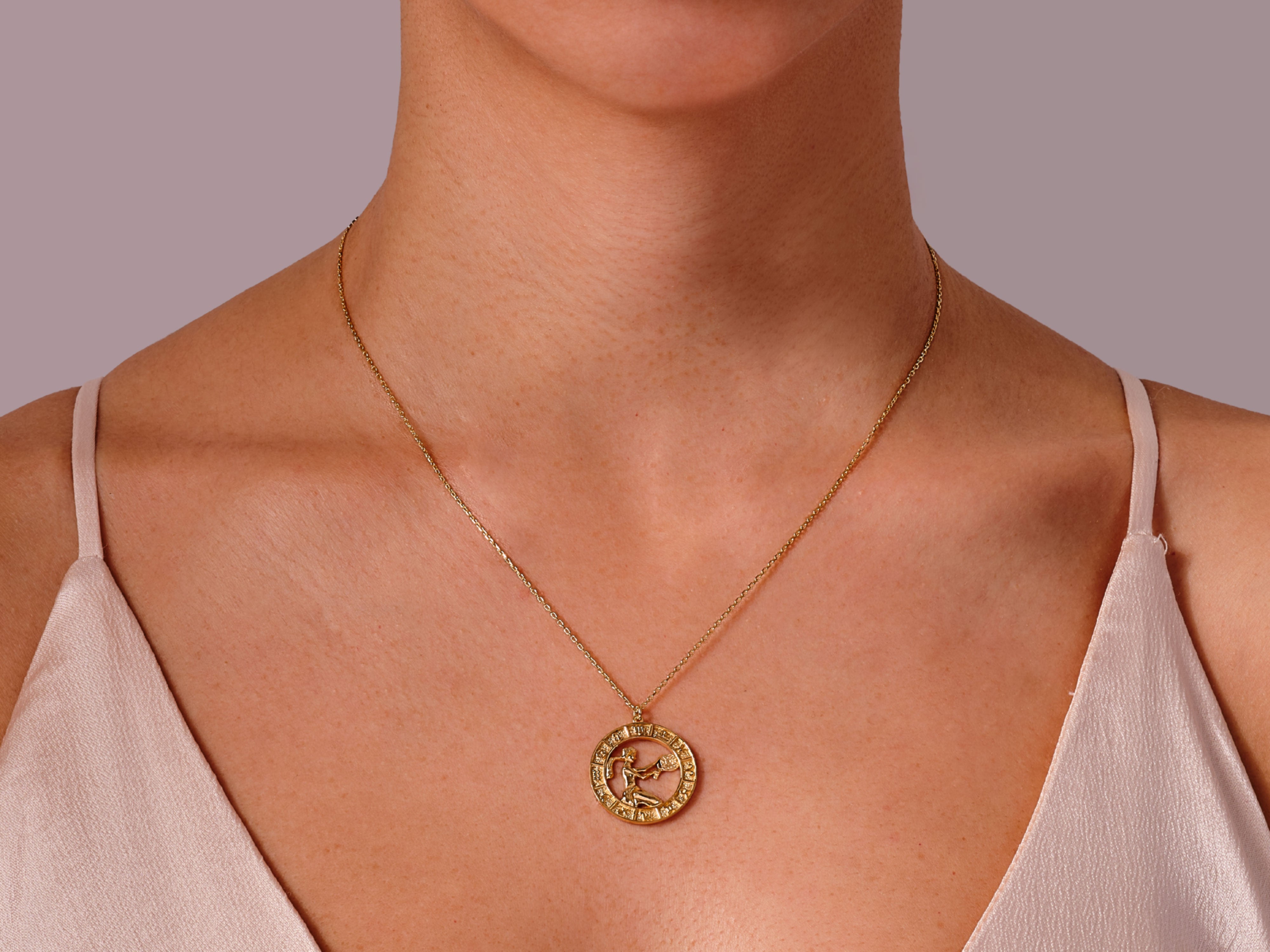 Gold zodiac necklace on a woman's neck, jewelry for sale
