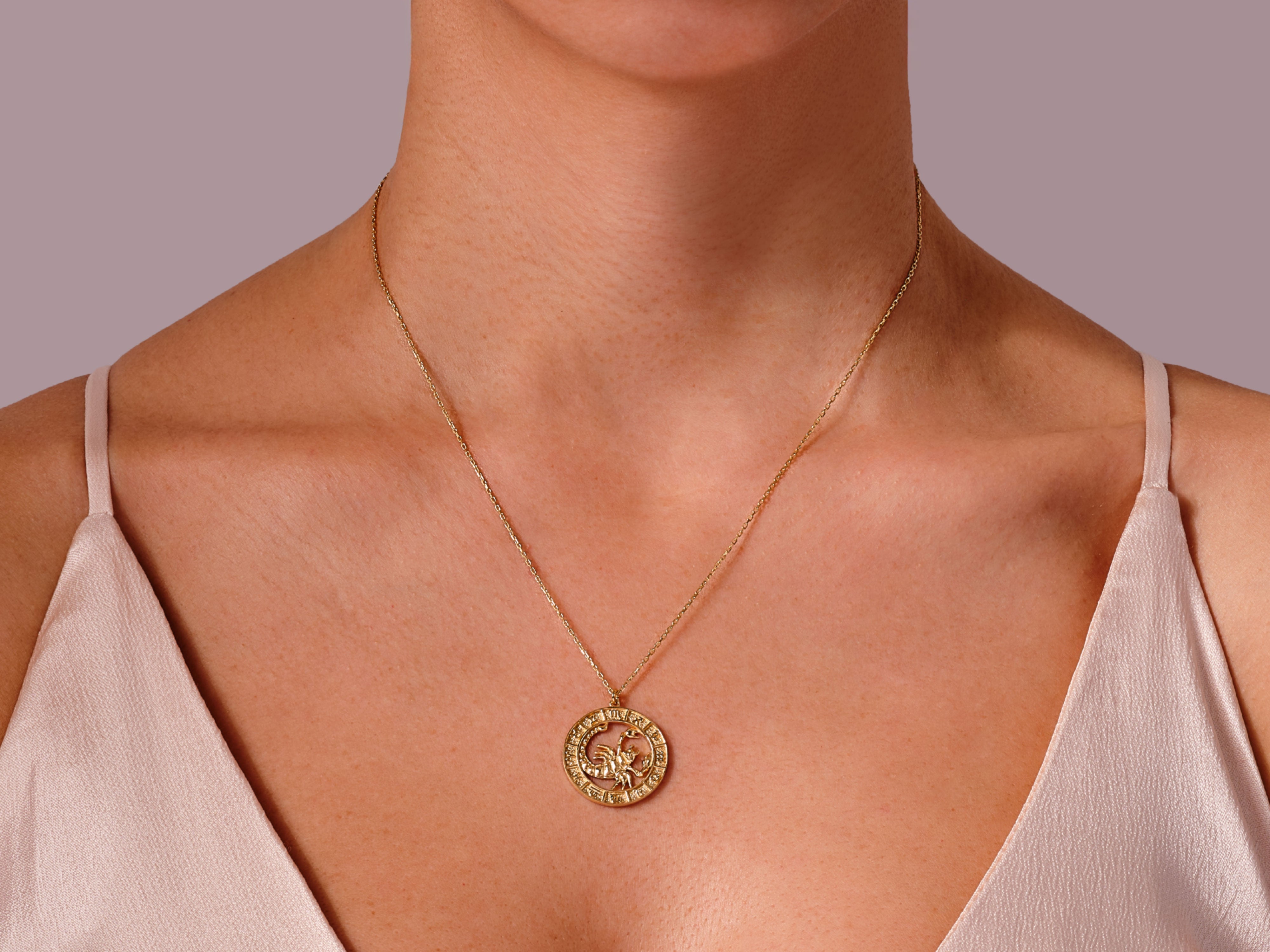 Gold Scorpio zodiac necklace on a woman's neck