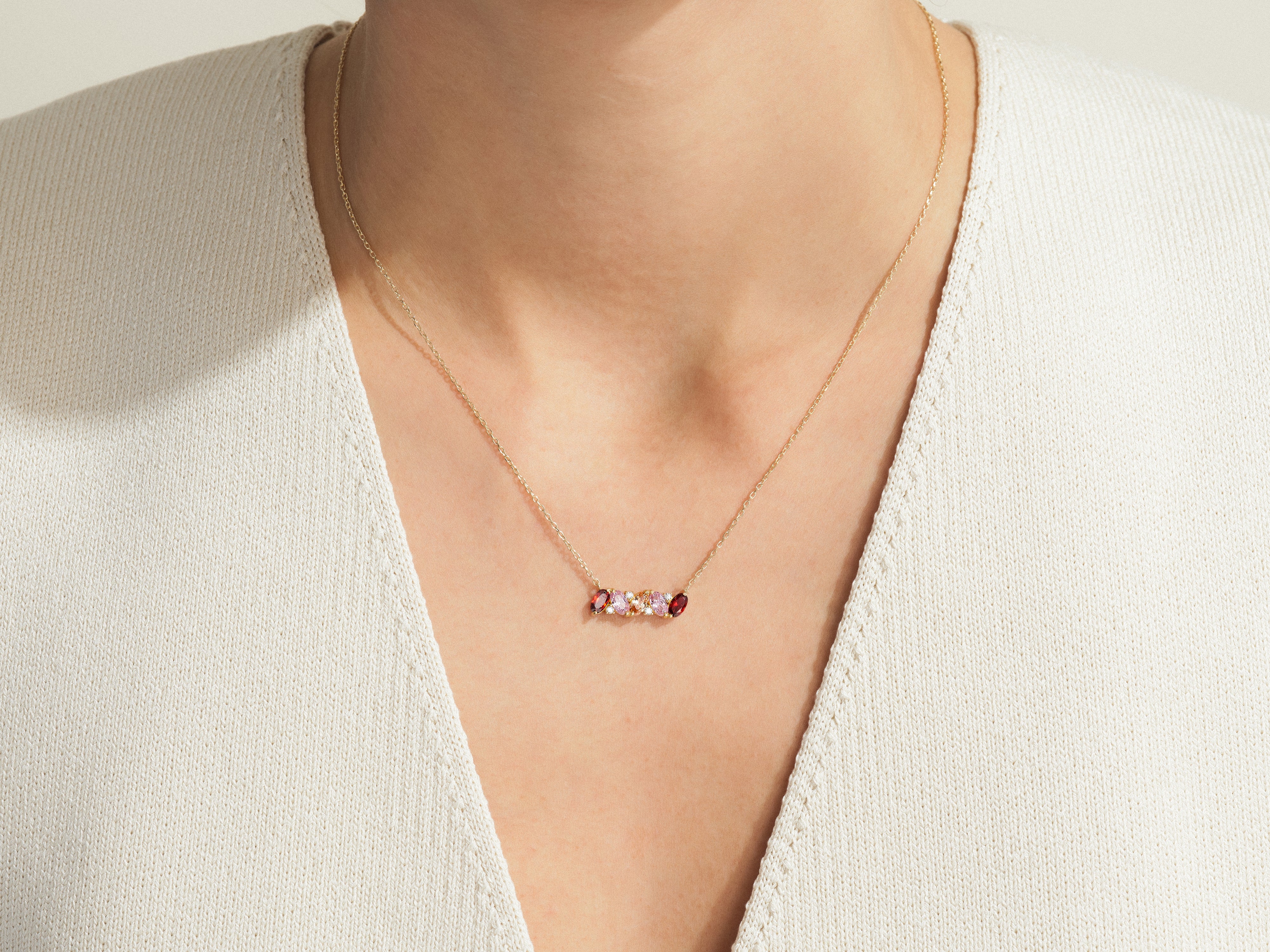 Gold necklace with colorful gemstones on a woman's neck