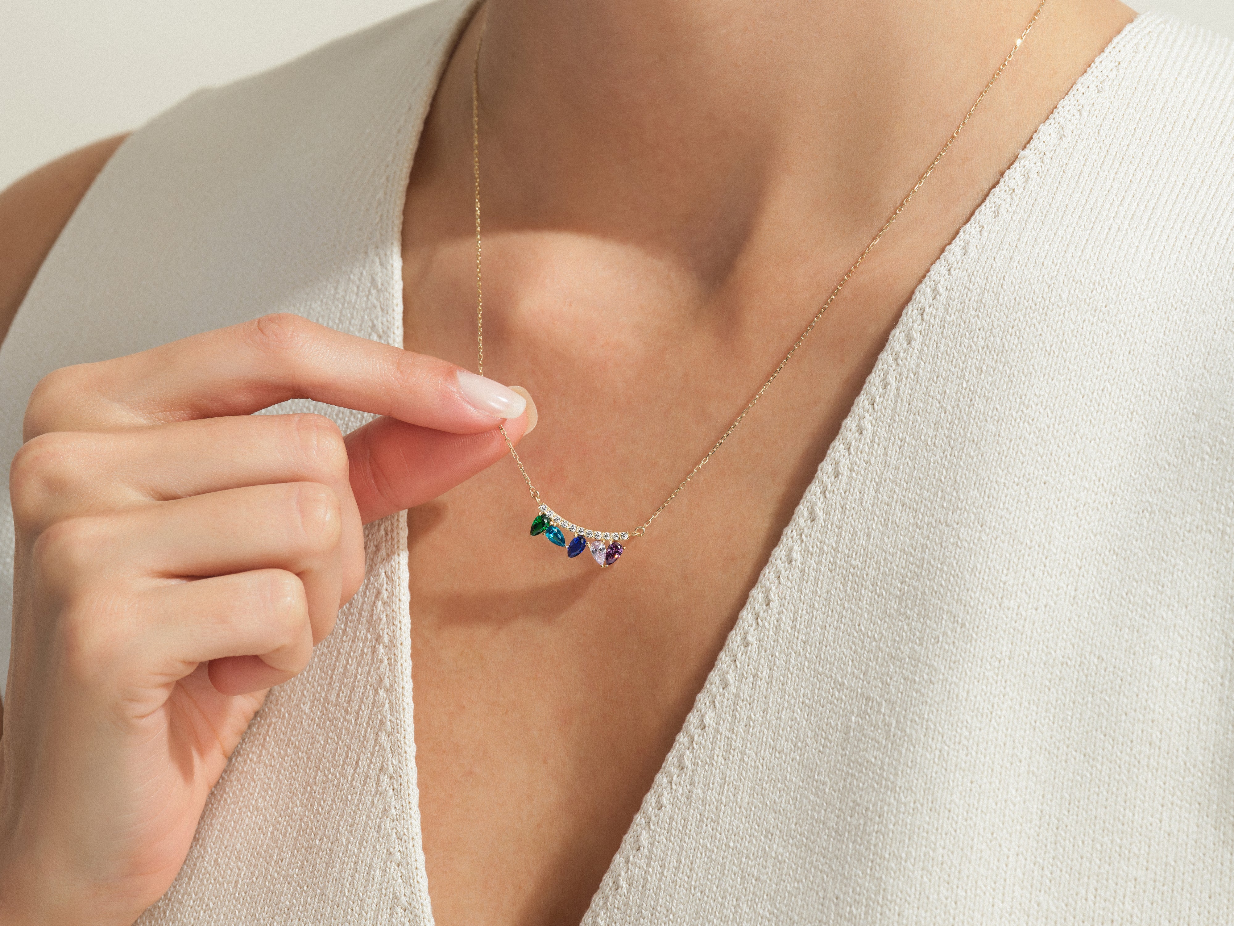 Gold necklace with colorful gemstones and diamonds on a woman's neck