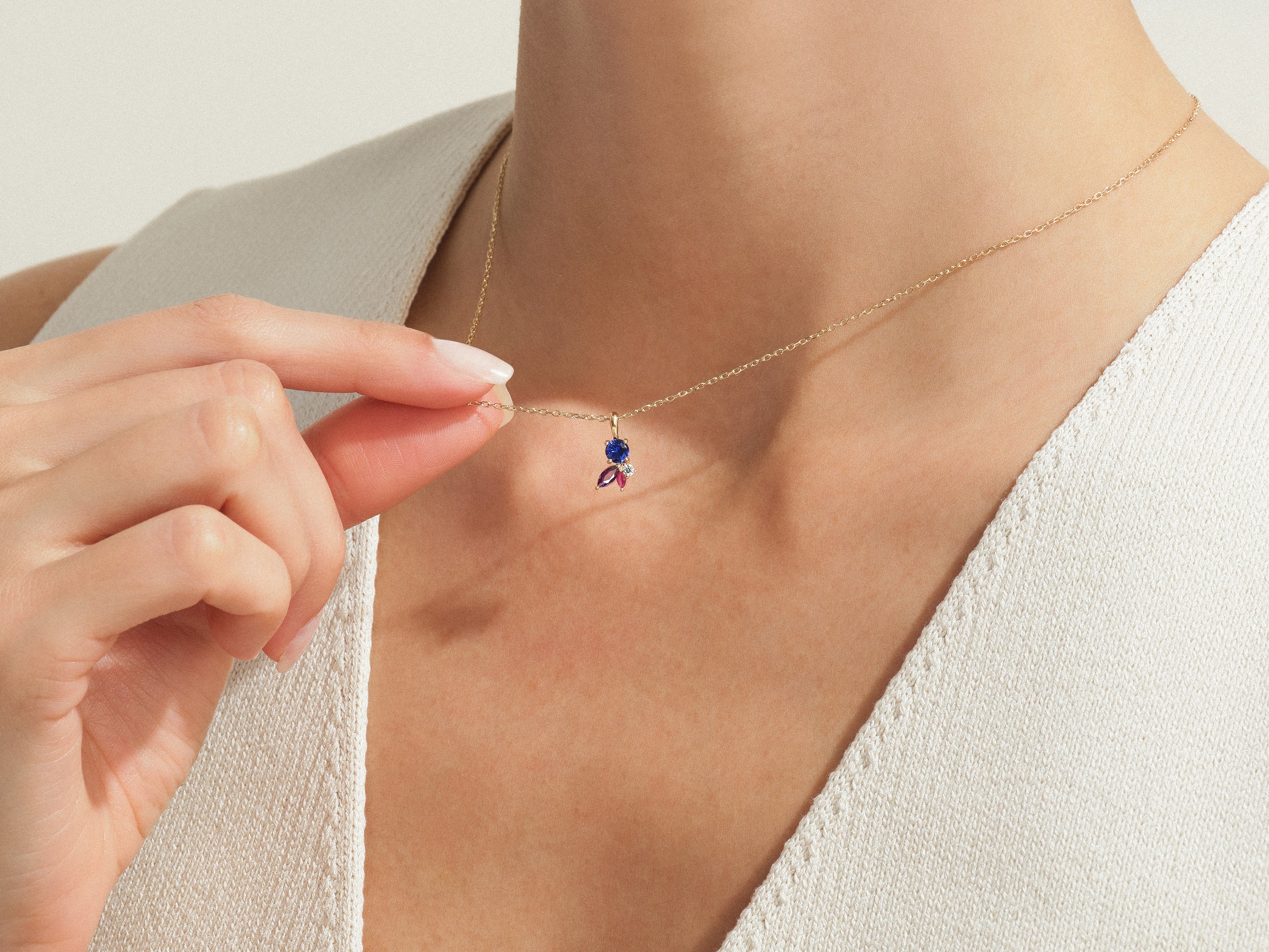 Gold necklace with sapphire, ruby, and diamond pendant