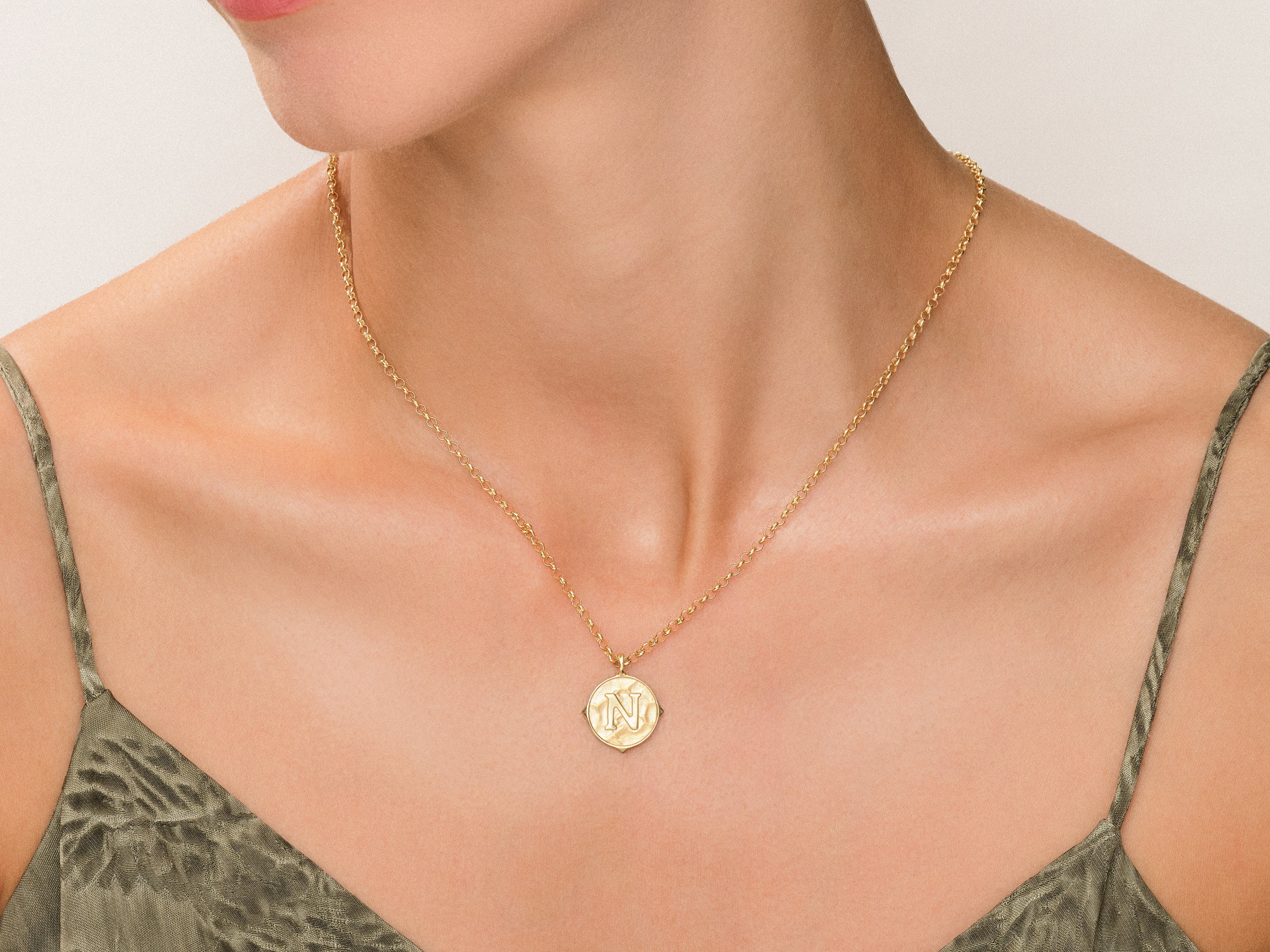 Gold initial 'N' pendant necklace on a woman's neck