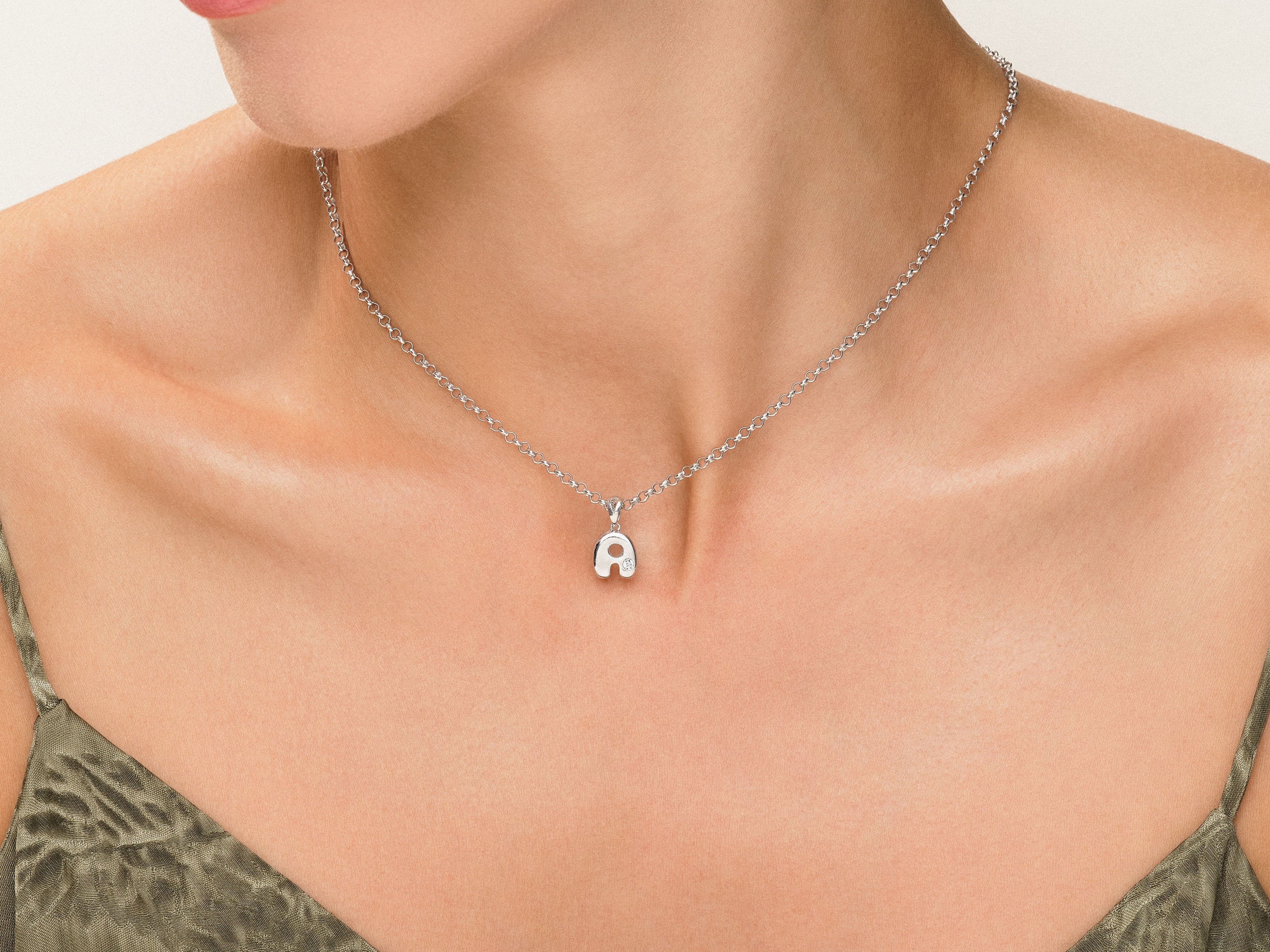 Silver initial 'A' necklace on a woman's neck
