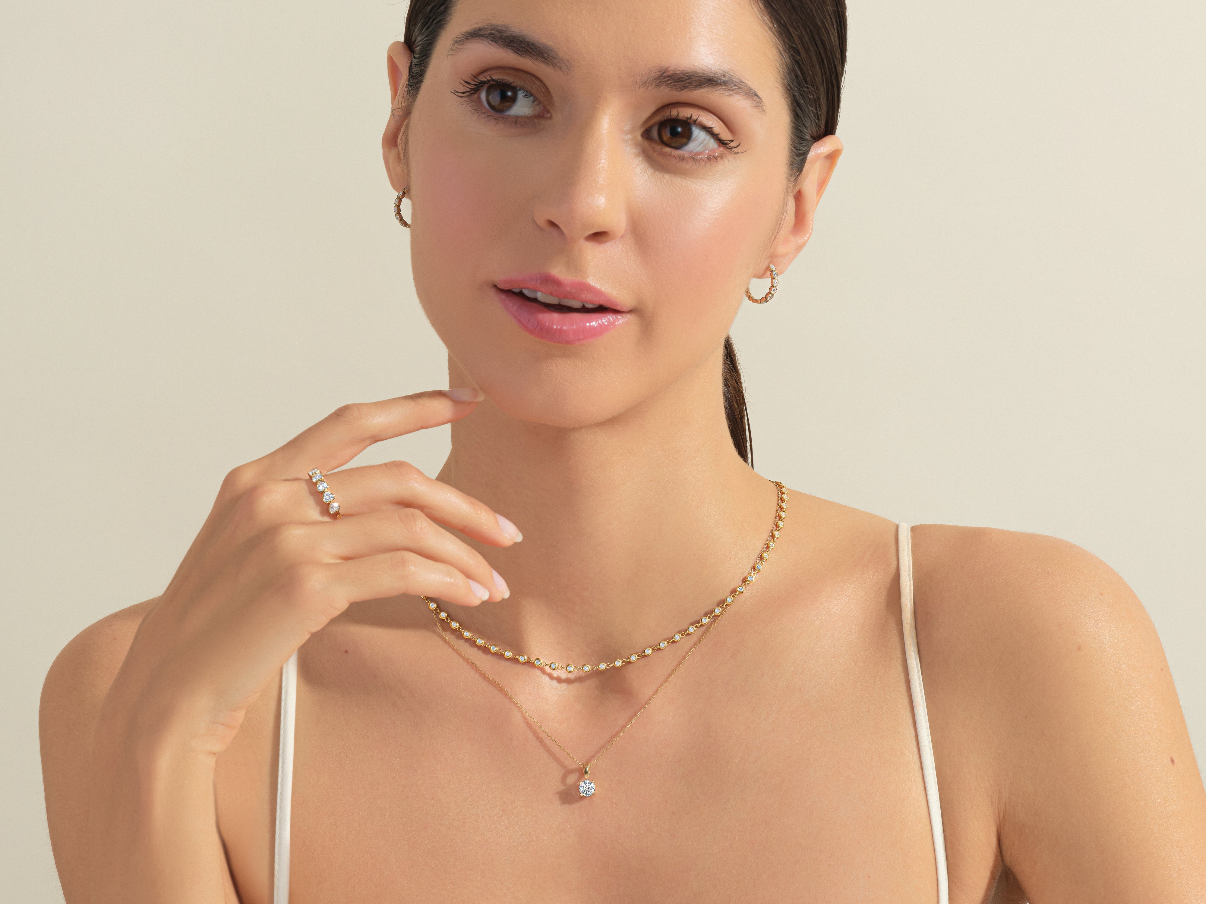 Woman wearing diamond necklace, ring, and earrings from jewelry brand