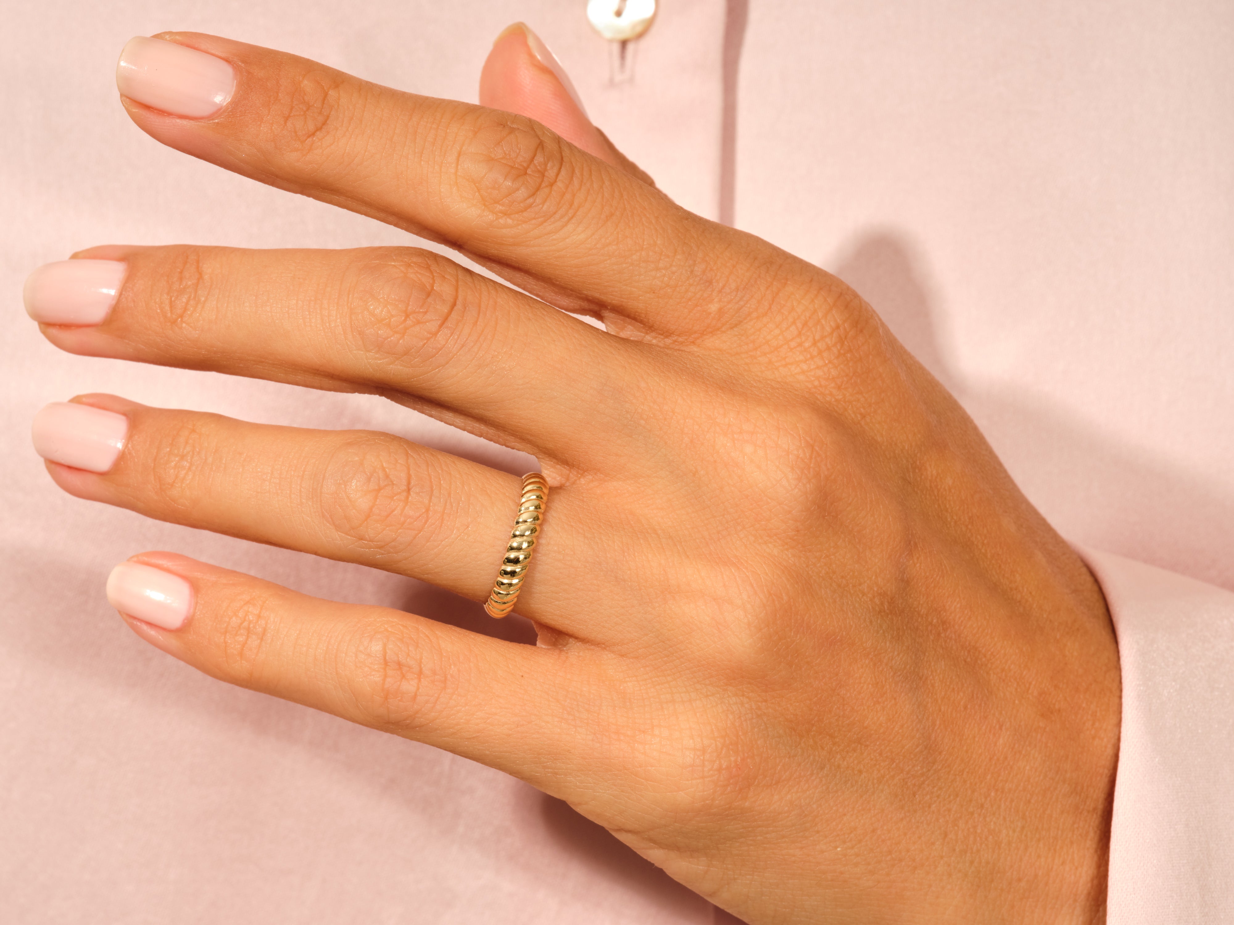 Gold twisted ring on a woman's finger, jewelry product