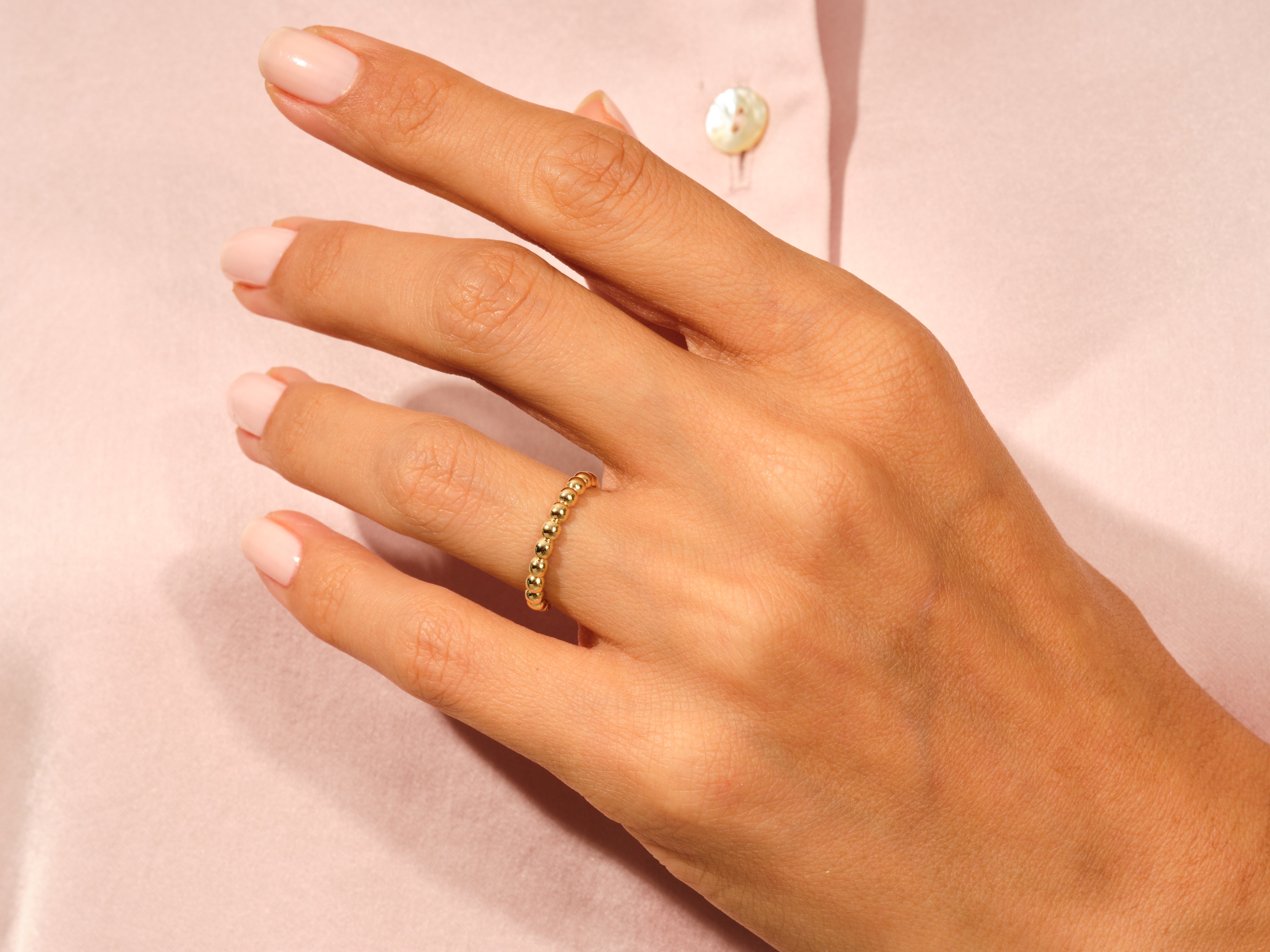 Gold beaded ring on a hand, jewelry product photography