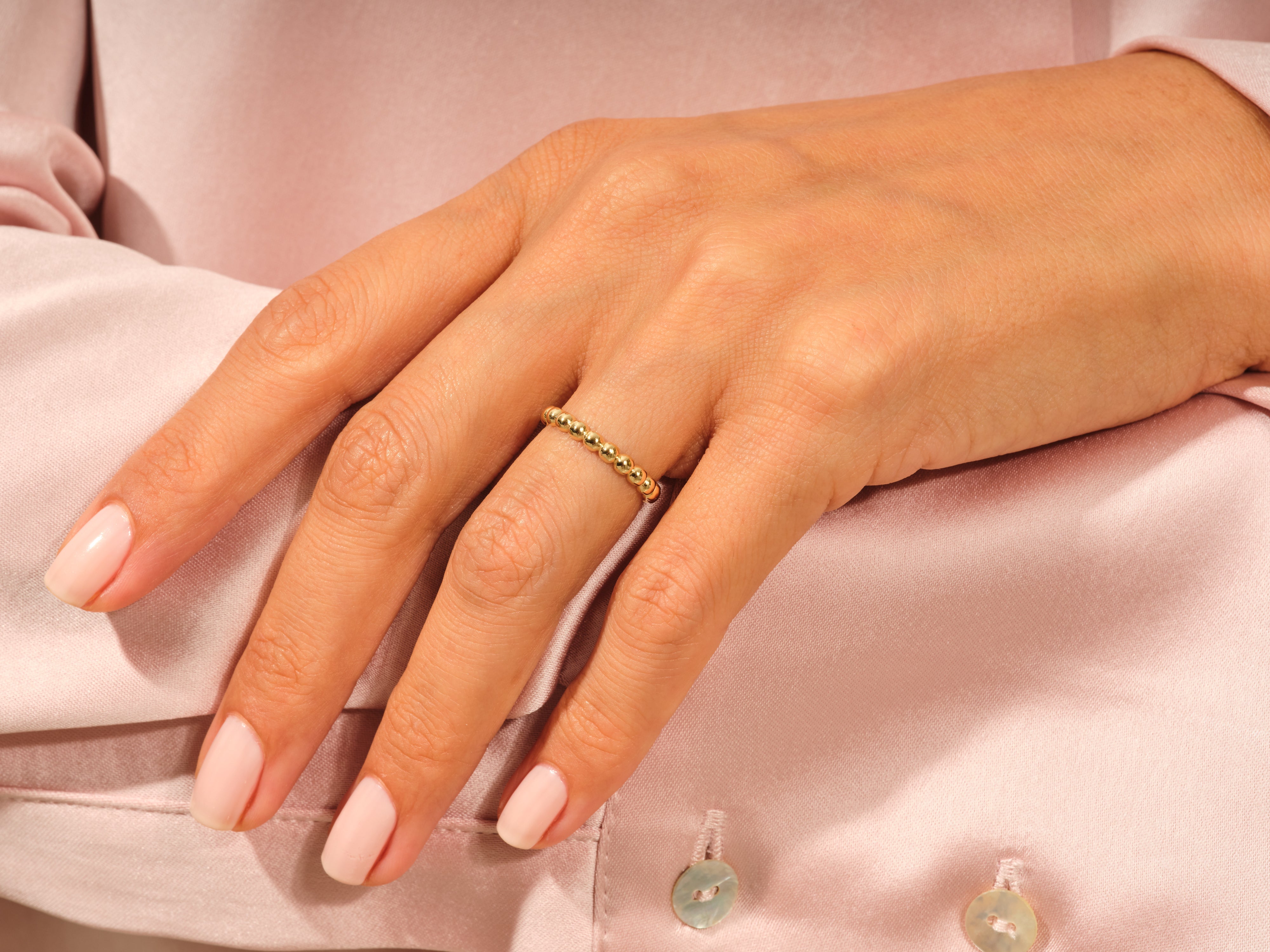 Gold beaded ring on a woman's finger, jewelry product shot