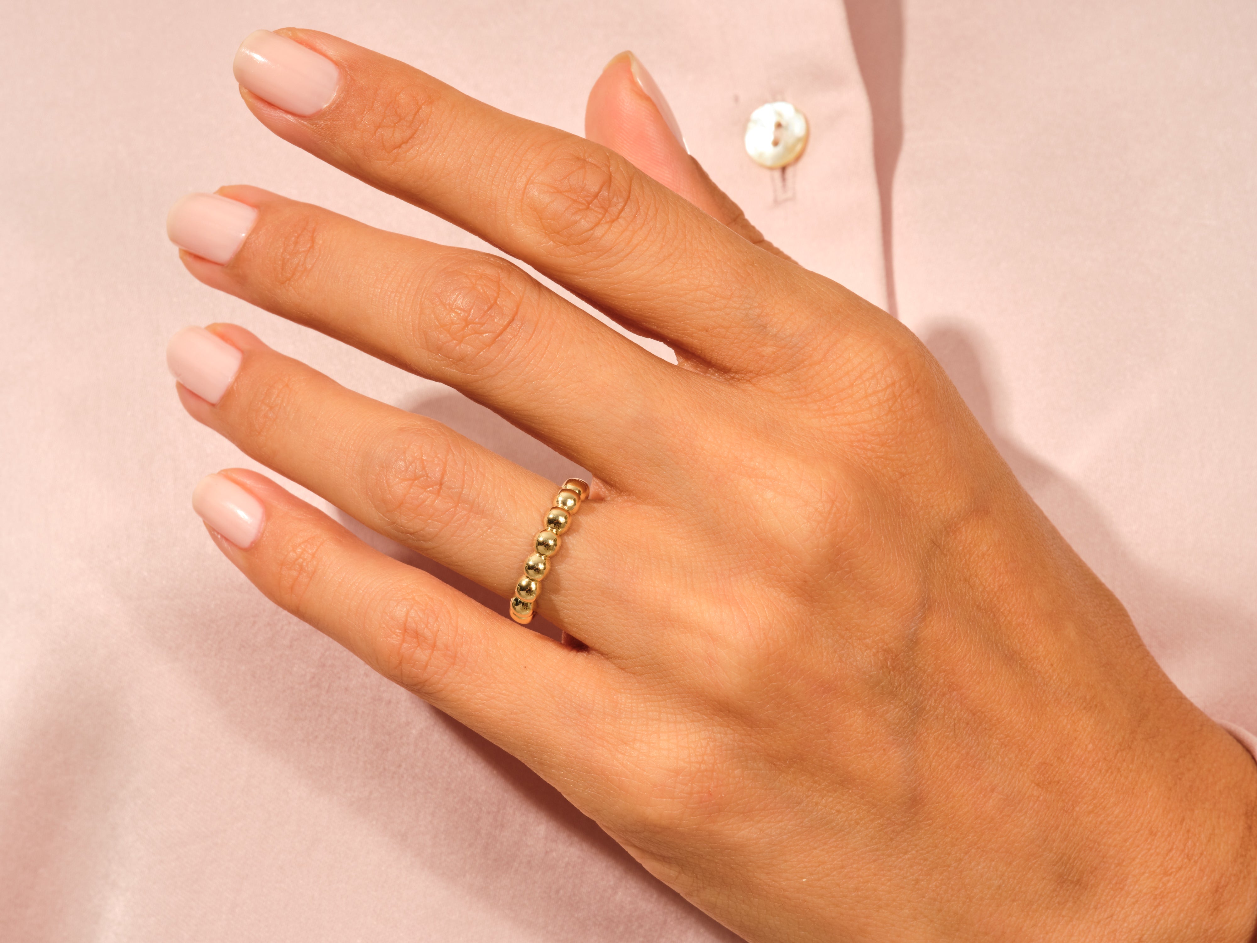 Gold beaded ring on a hand, jewelry product photography