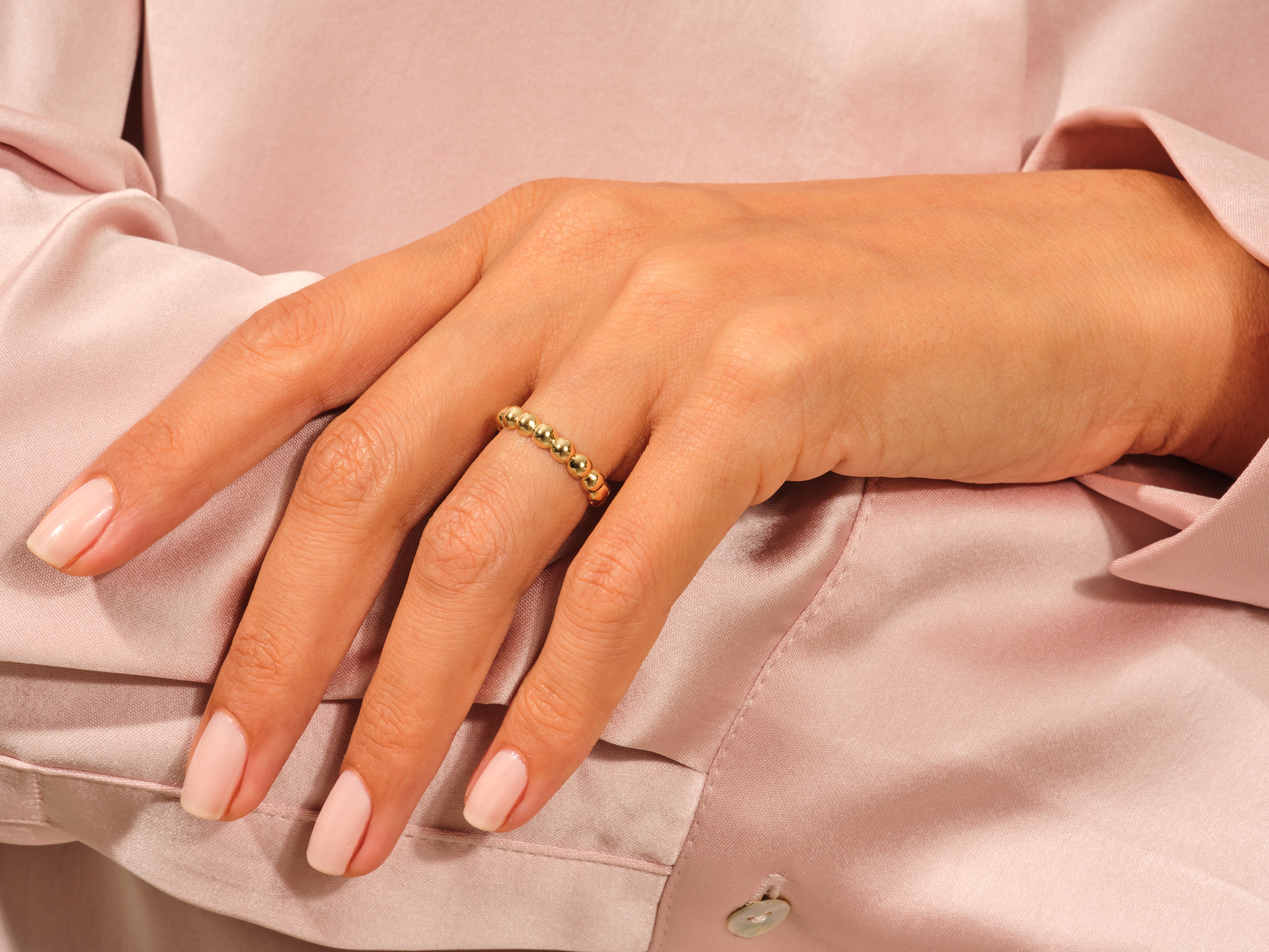 Gold beaded ring on a woman's hand, jewelry product