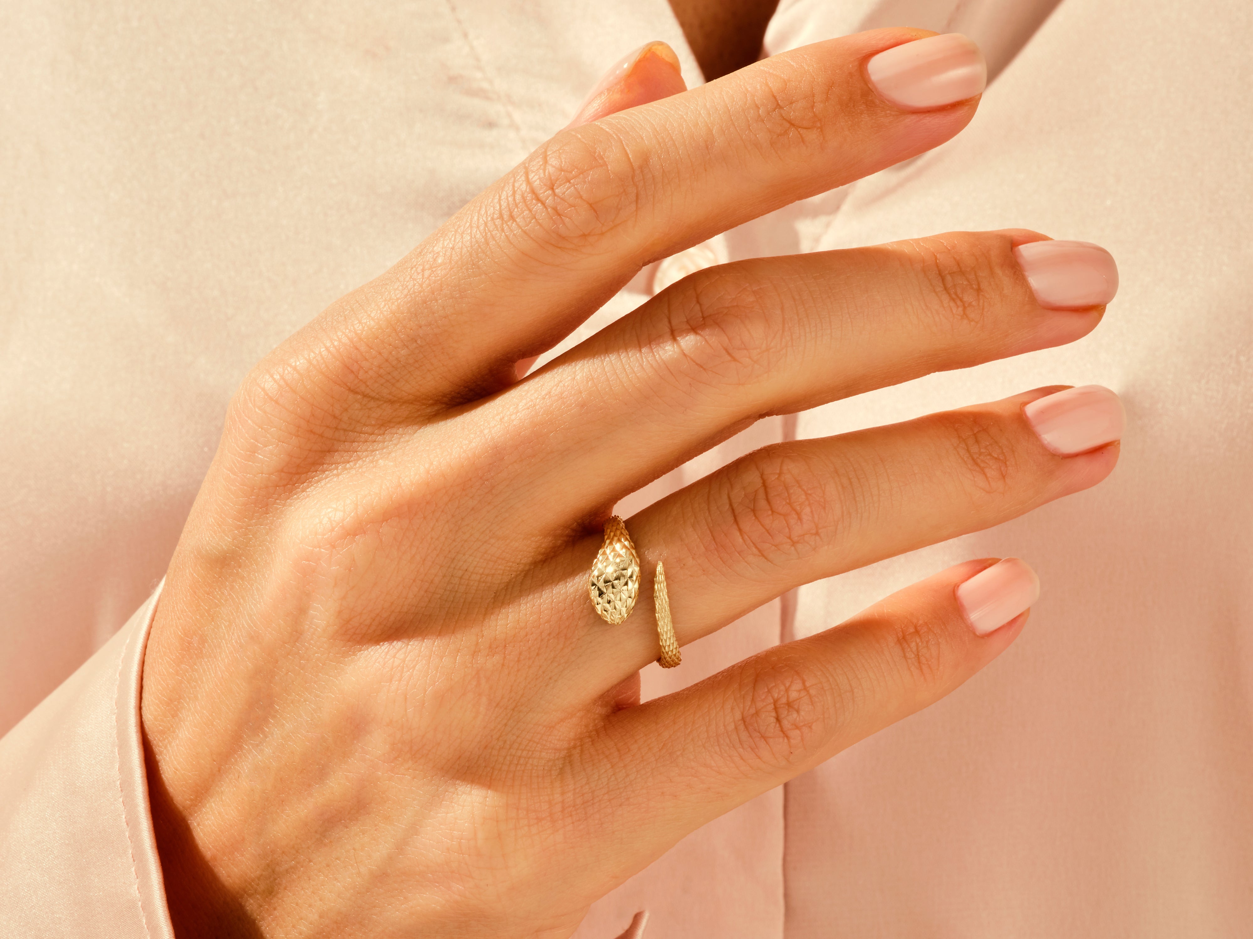 Gold snake ring on a woman's hand, elegant jewelry