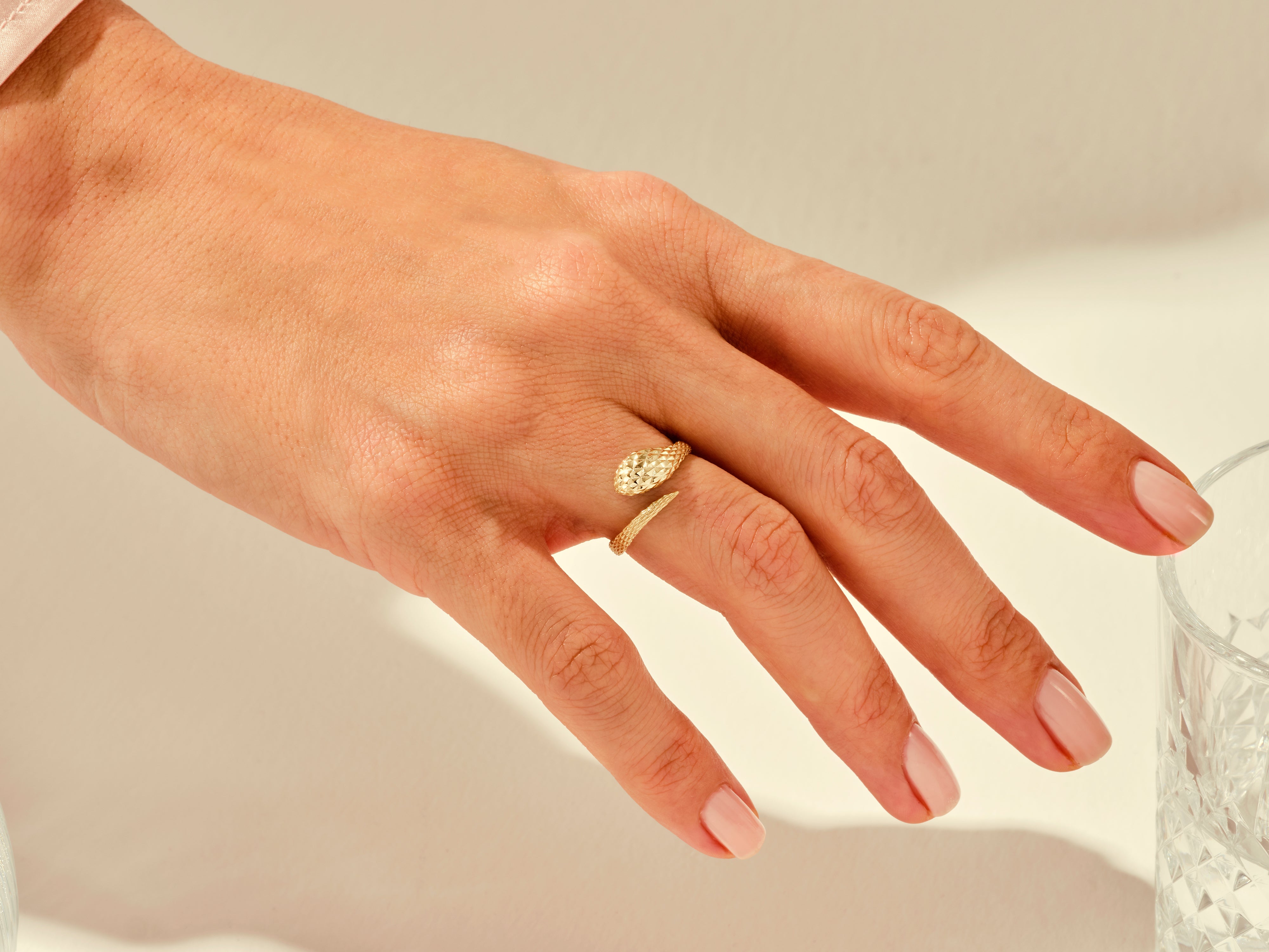 Gold snake ring on a hand, fine jewelry for women