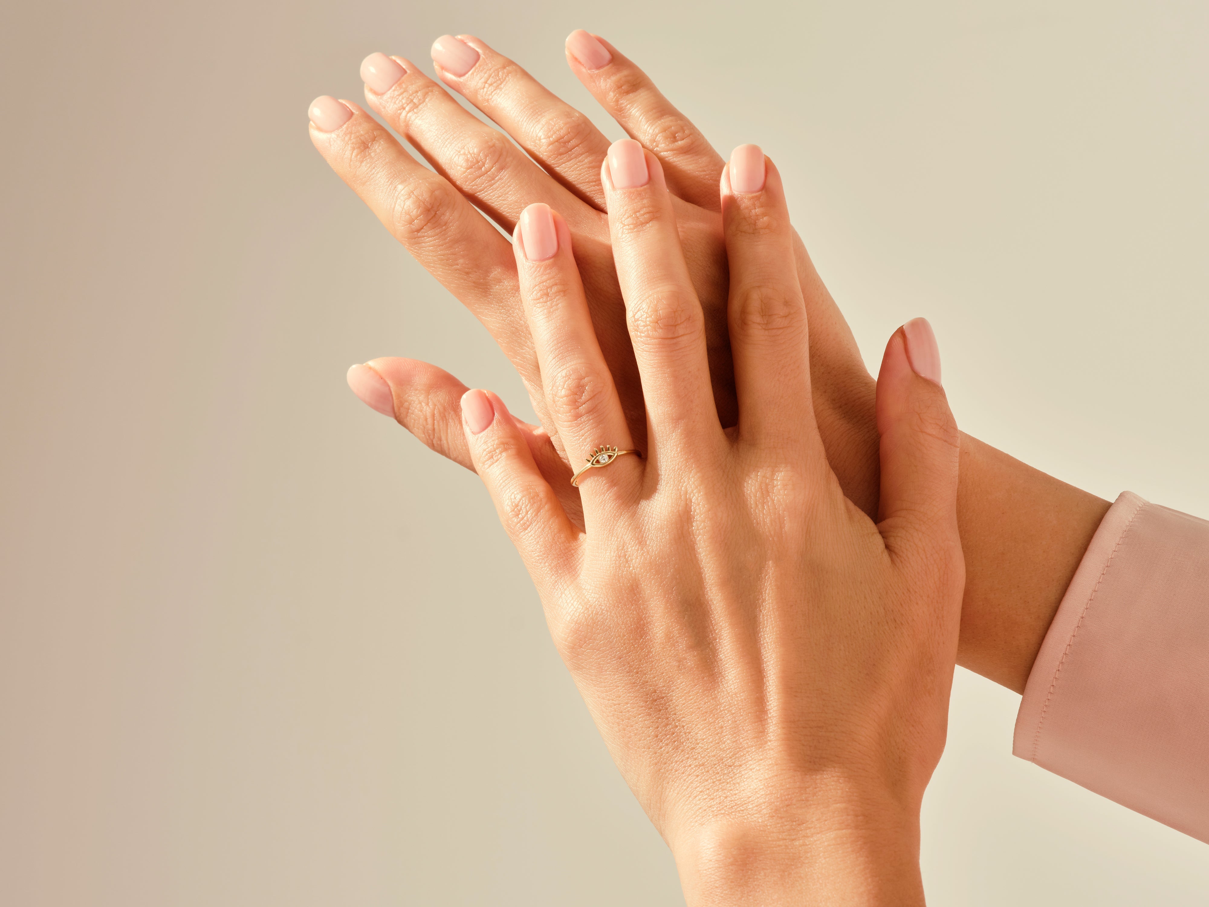 Elegant gold evil eye ring on a woman's hand, jewelry photography