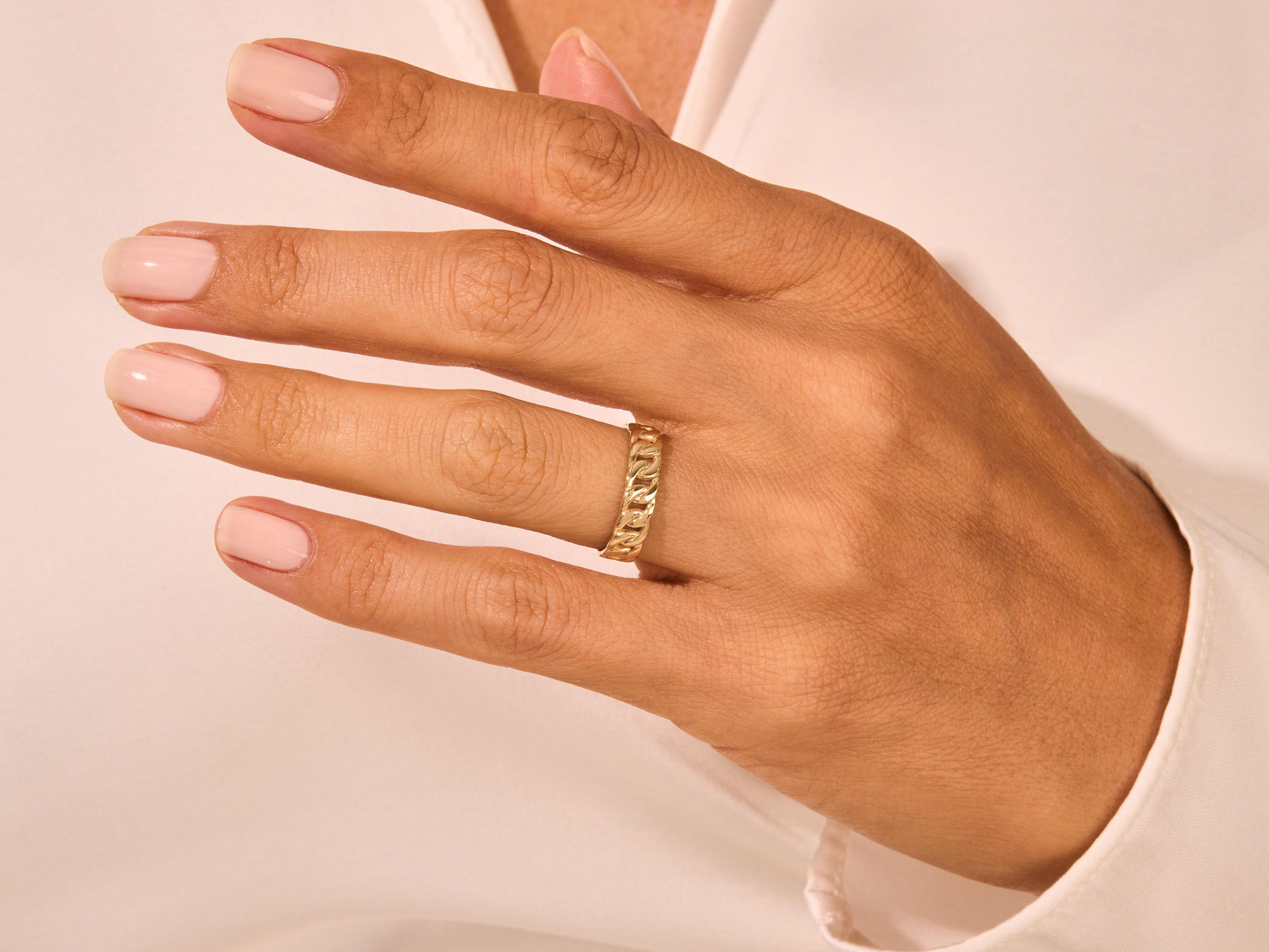 Gold curb chain ring on a woman's finger, fine jewelry