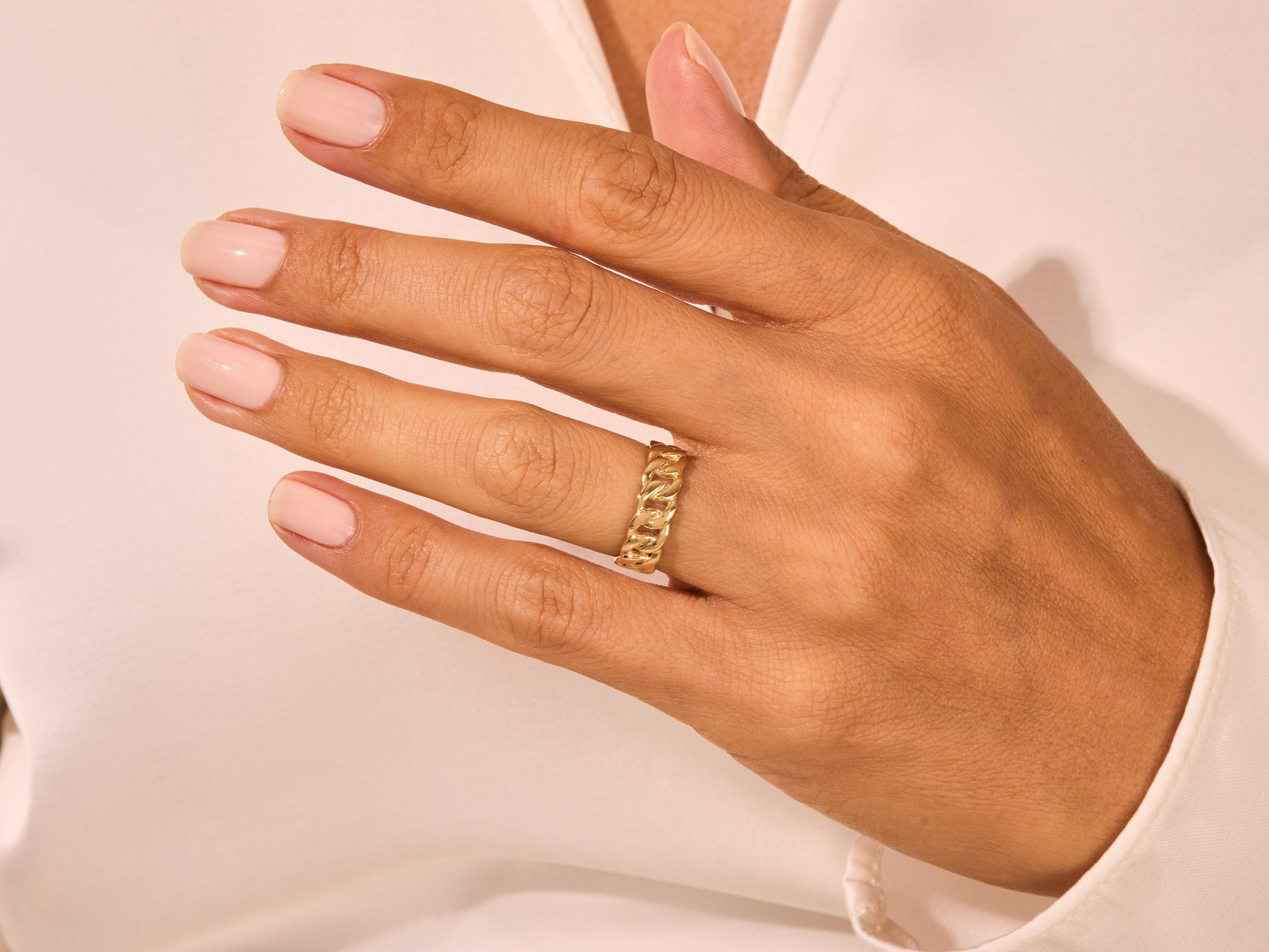 Gold curb chain ring on a hand, jewelry product