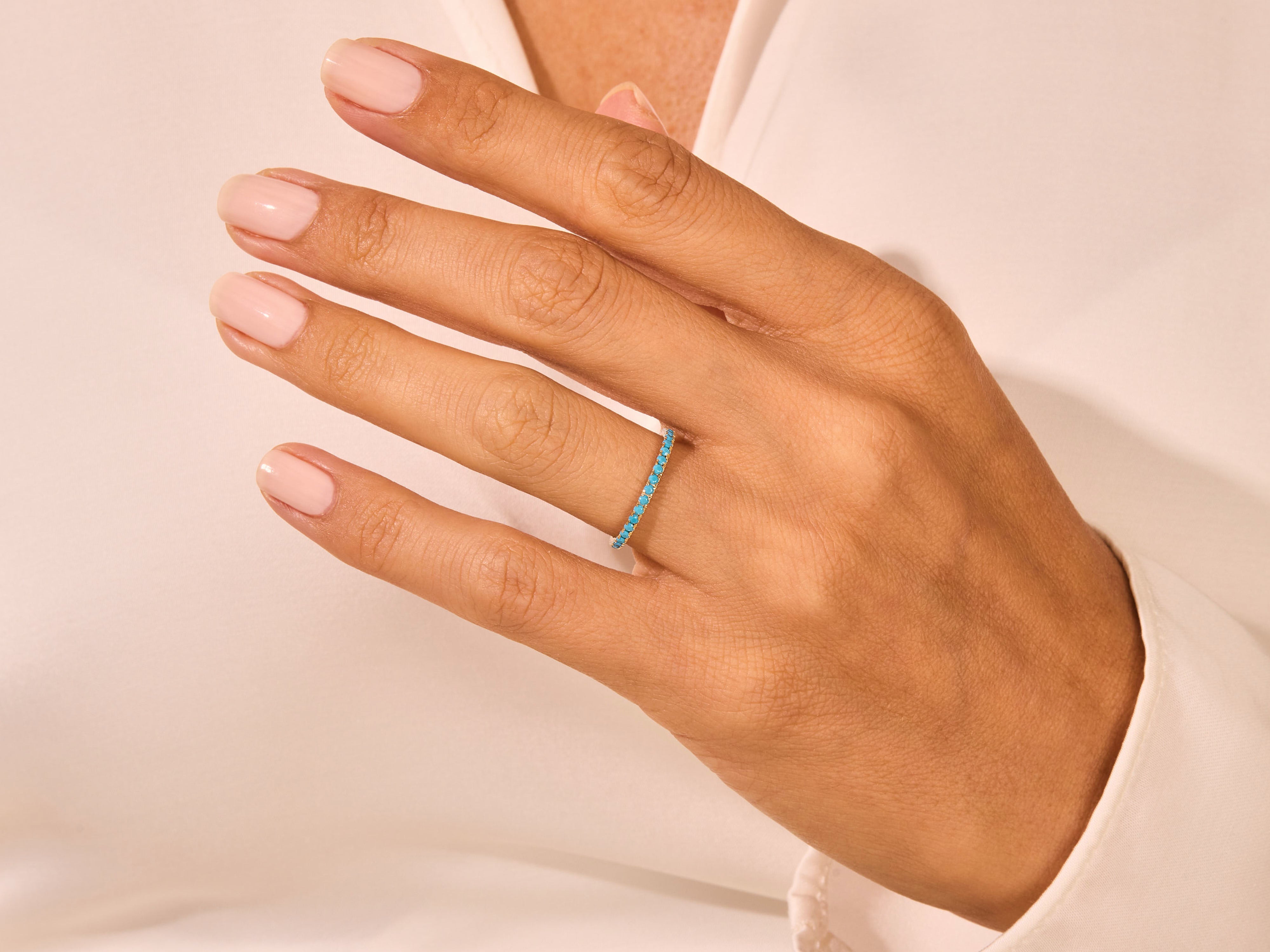 Turquoise eternity band ring on a woman's finger