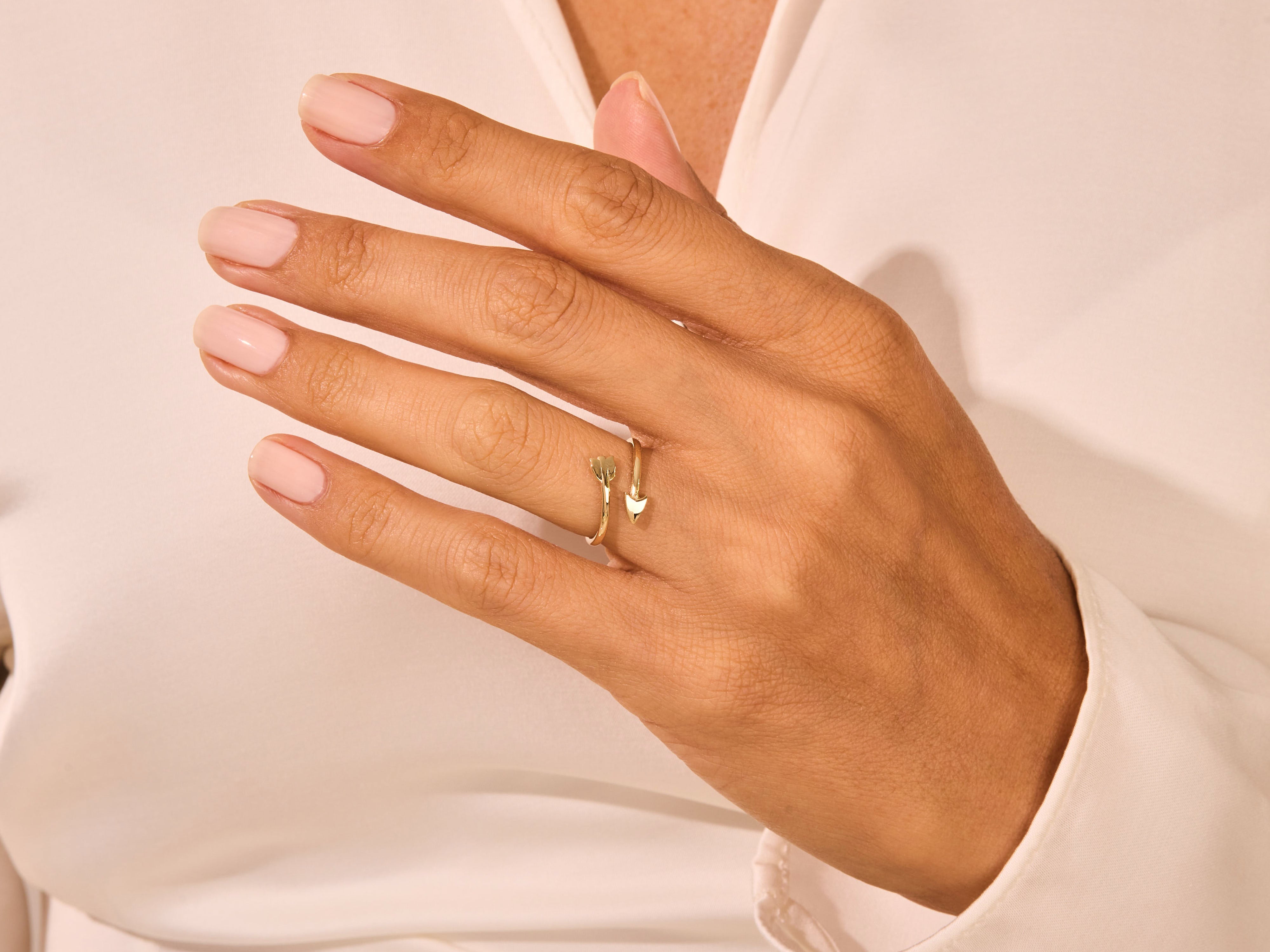 Gold arrow ring on a woman's hand, fine jewelry