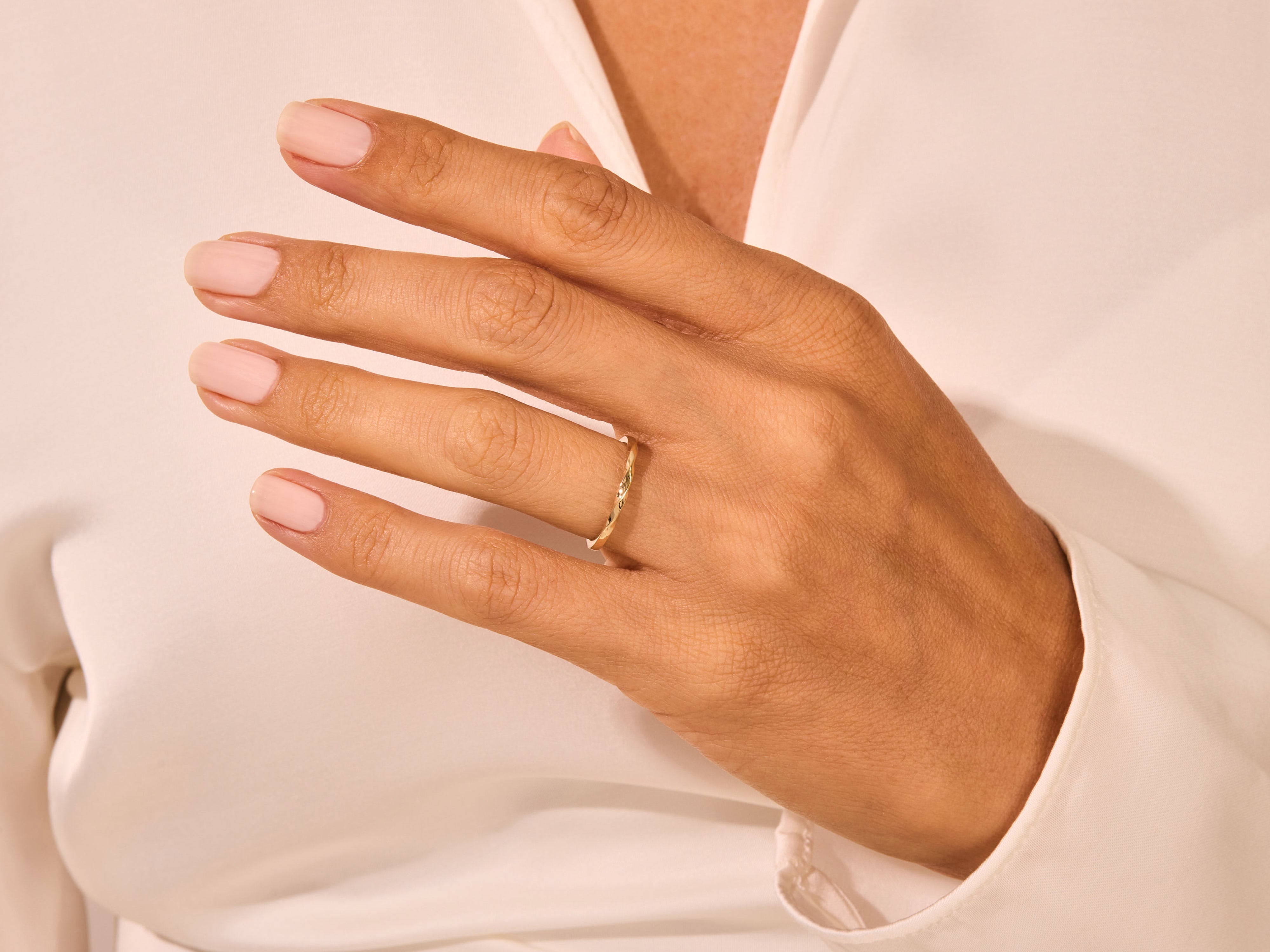 Delicate gold ring on a woman's hand, showcasing fine jewelry craftsmanship
