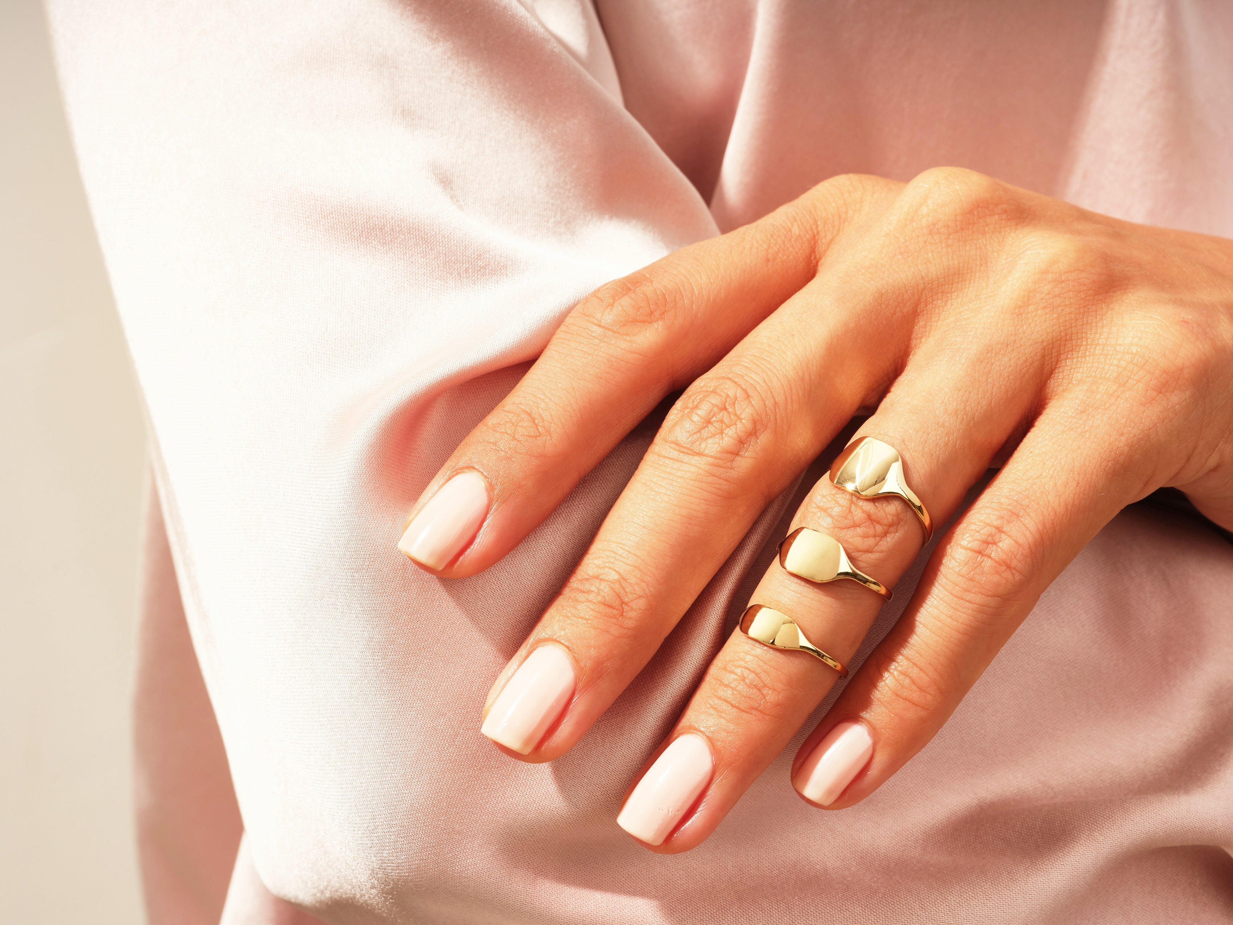 Gold signet rings on a hand, jewelry for women