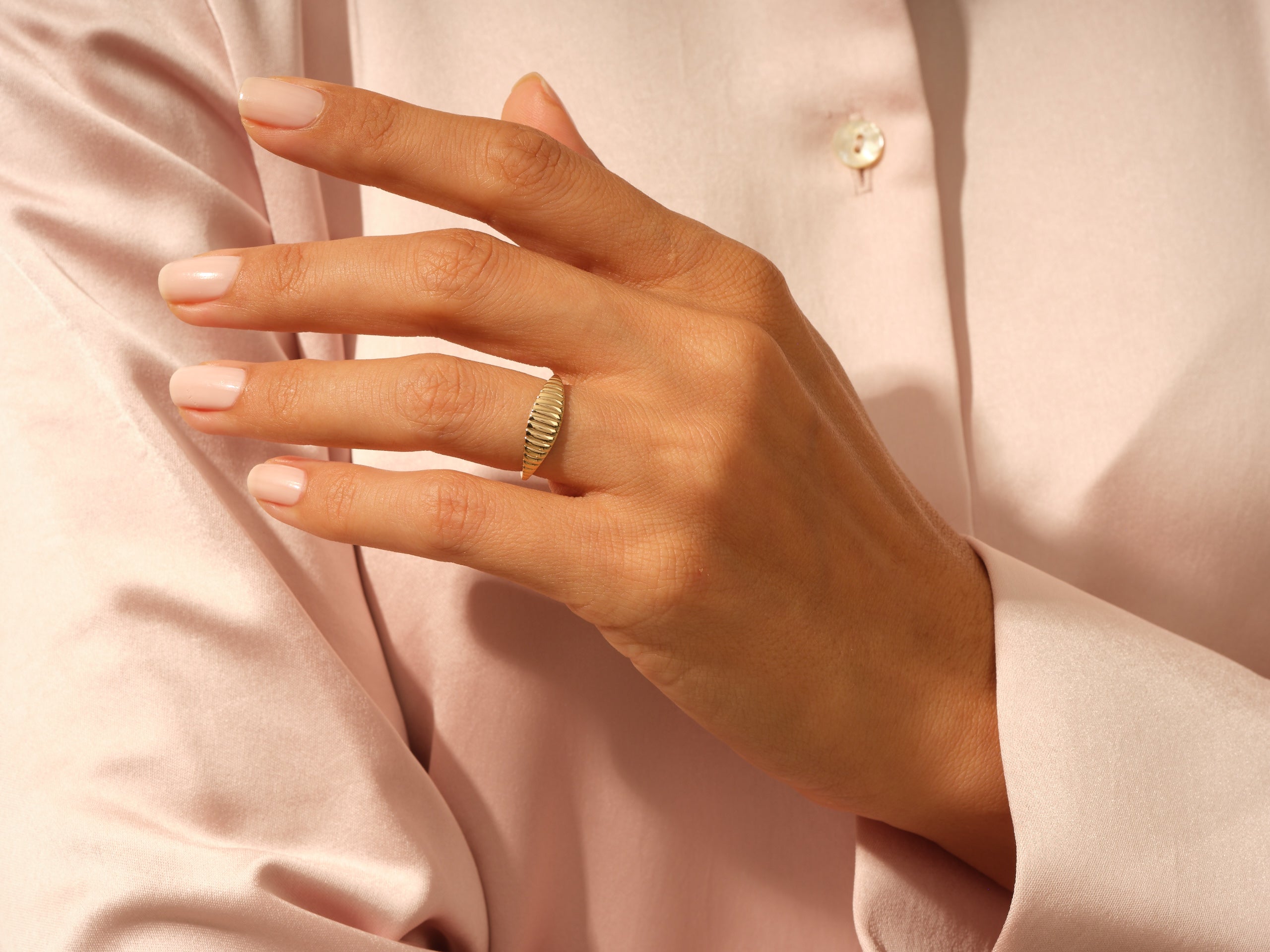 Gold ribbed ring on a woman's finger, jewelry photography