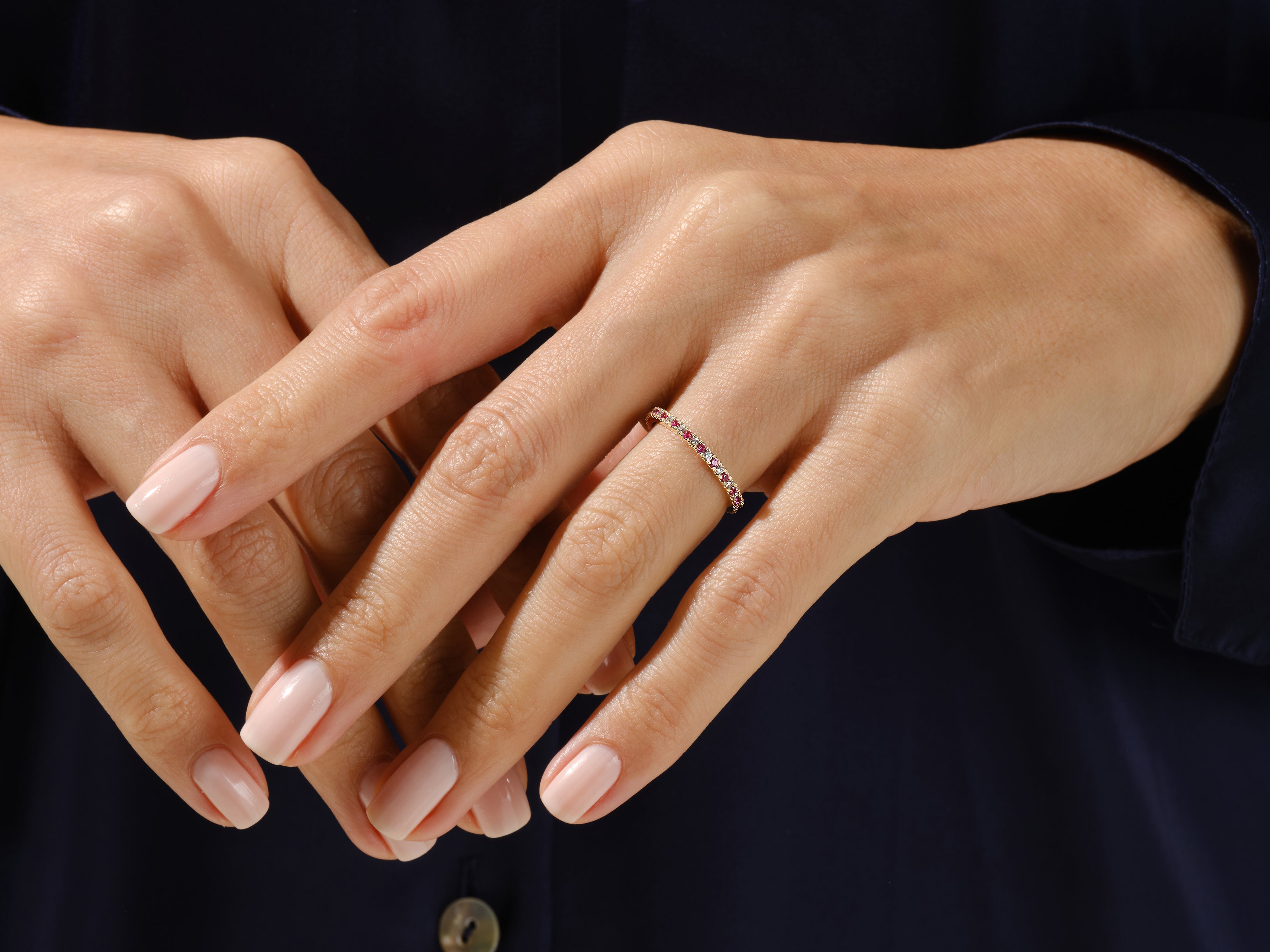 Delicate ruby and diamond band ring on a woman's hand
