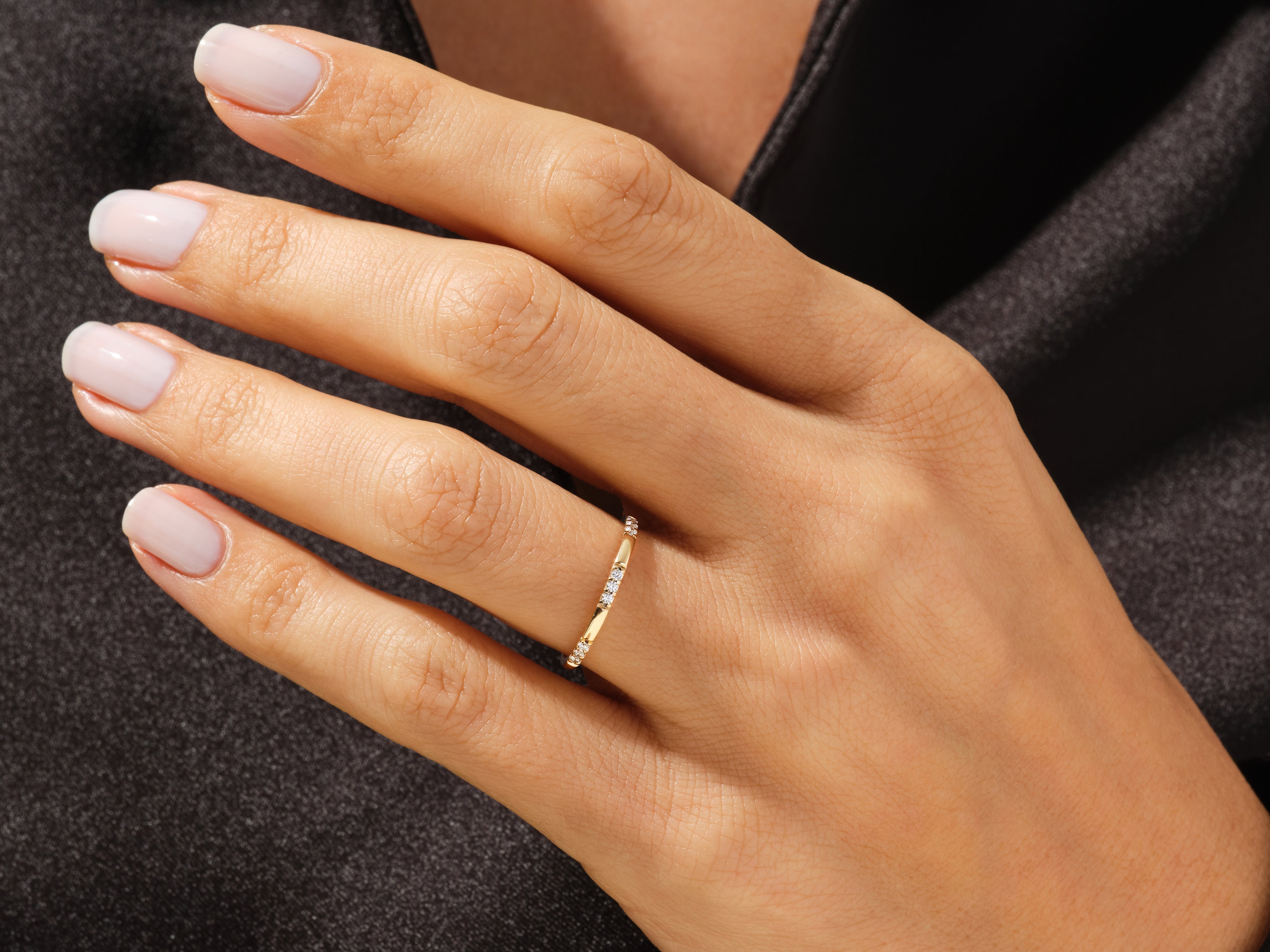 Gold diamond ring on a manicured hand, jewelry product photography
