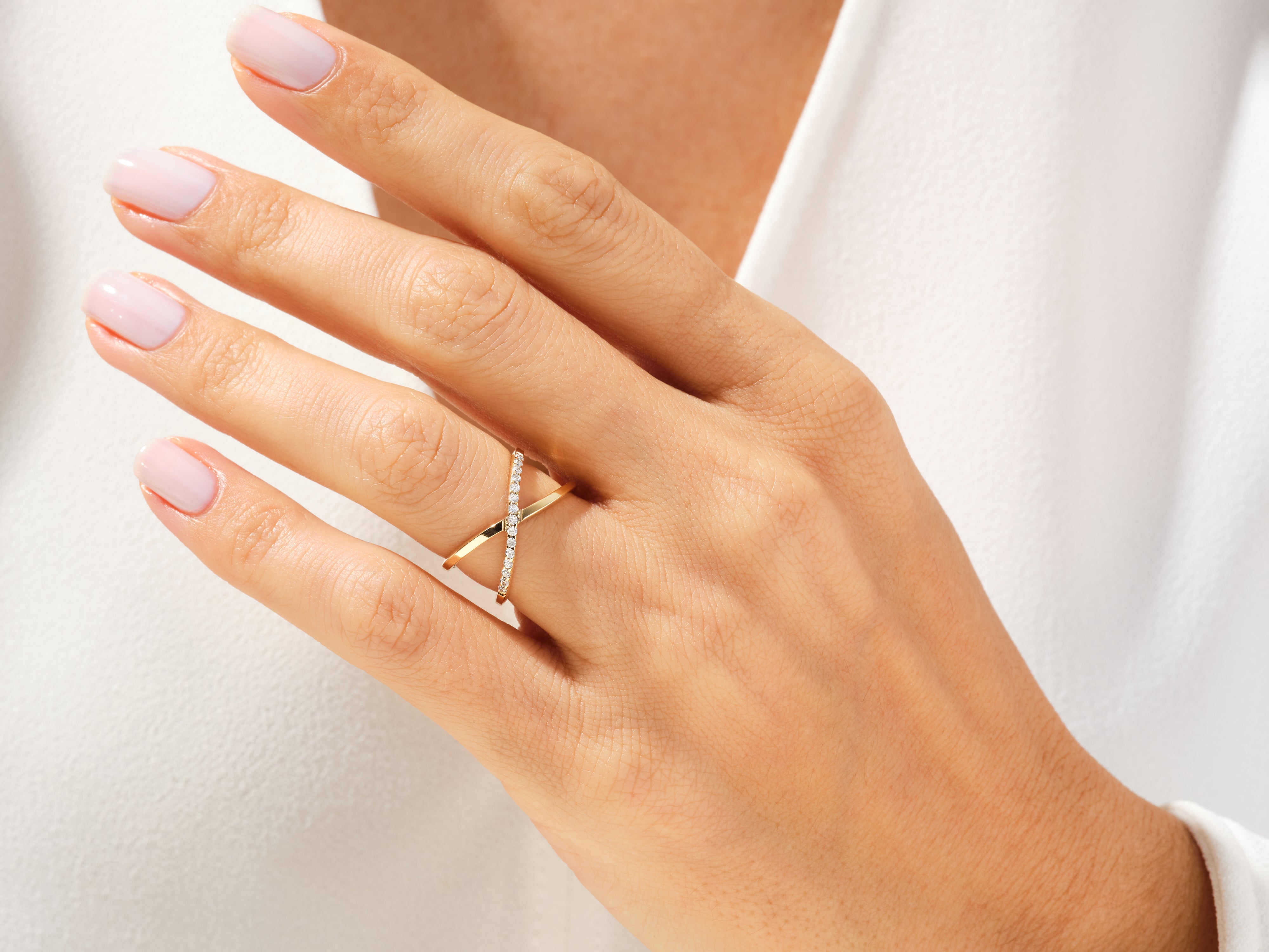 Diamond criss-cross ring on a woman's finger, fine jewelry